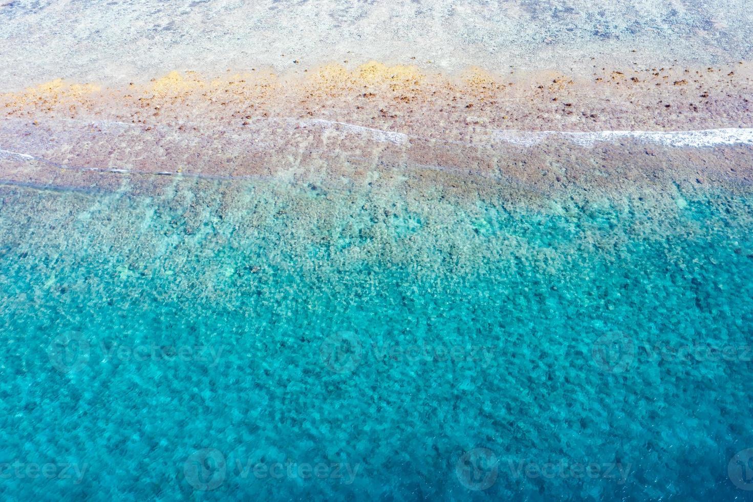 Aerial sea view, top view of amazing nature ocean background. Bright blue water colors, lagoon beach with waves splashing at sunny day. Flying drone photo, amazing nature landscape with coral reef photo