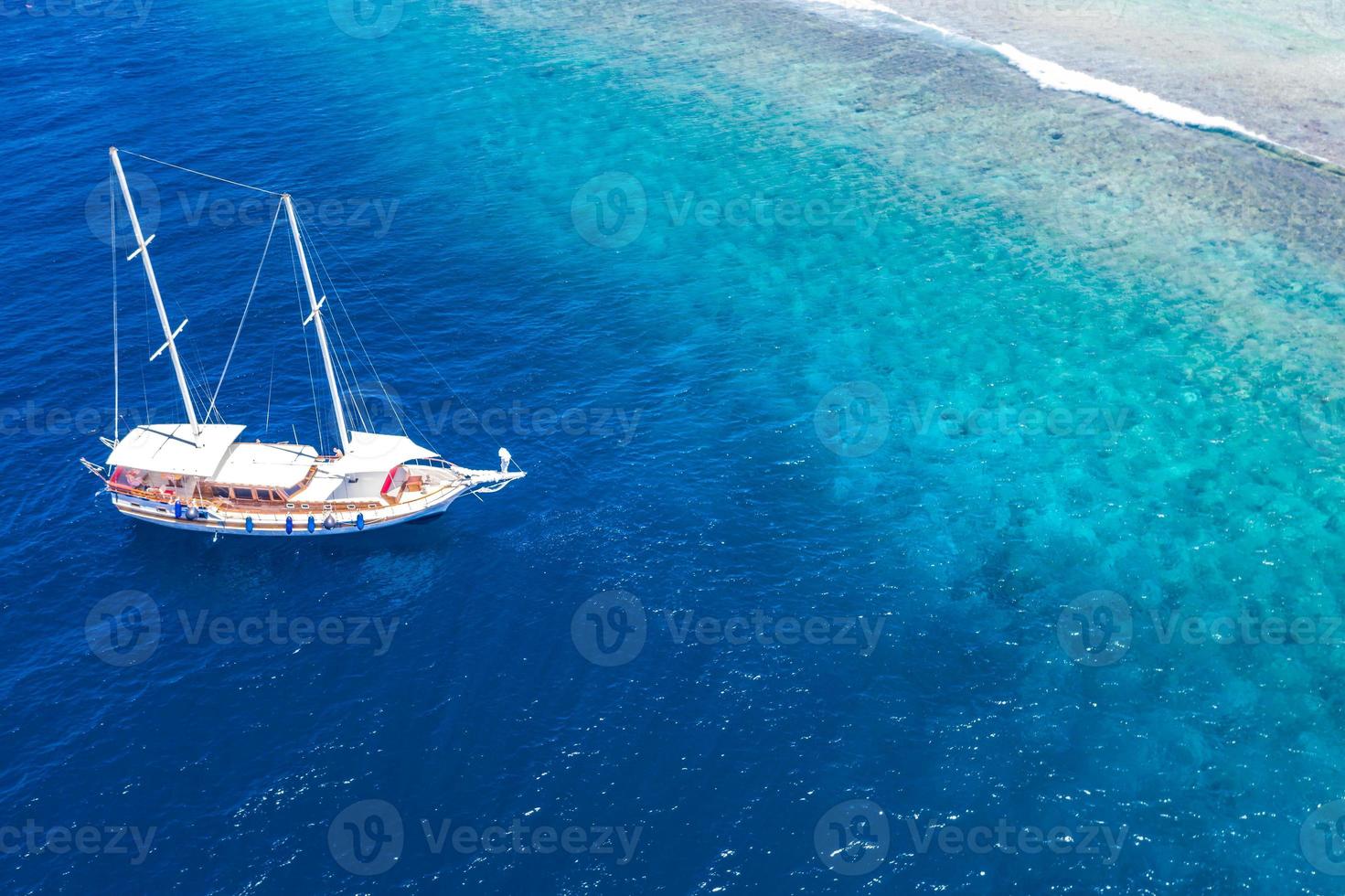 vista aérea del velero anclado en el arrecife de coral. vista de drones, tema de deportes acuáticos. Crucero de lujo y antecedentes de viajes marinos. hermoso paisaje natural, concepto de agua de mar océano. antena de maldivas foto