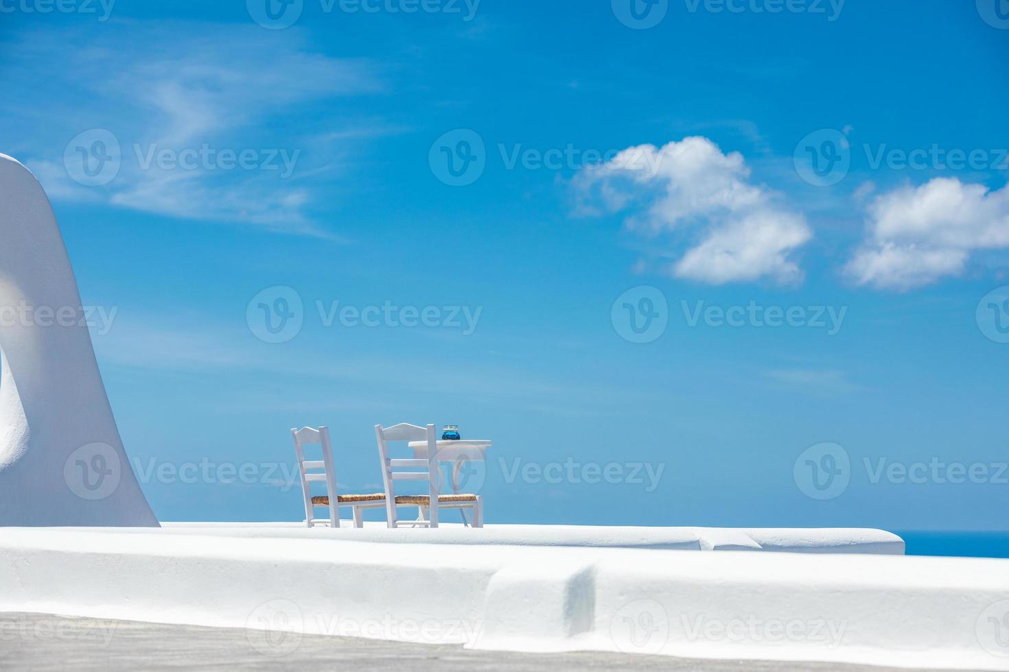 Romantic table set-up in Santorini Greece. White architecture and table for two. Love concept in romantic travel destination, summer holiday or vacation concept. photo