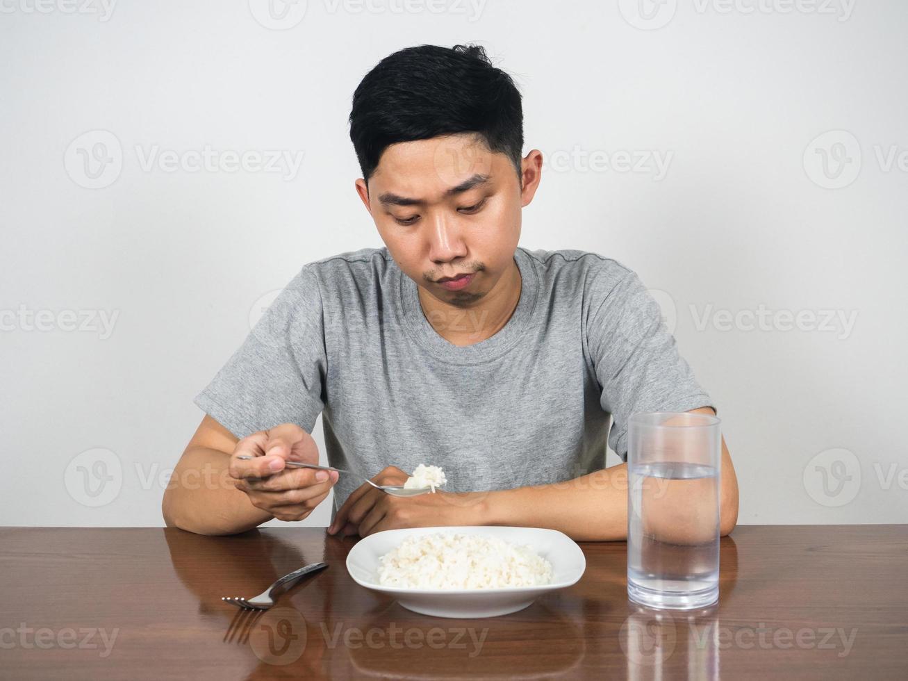 Young man feels bored food don't want to eatting rice on the table photo