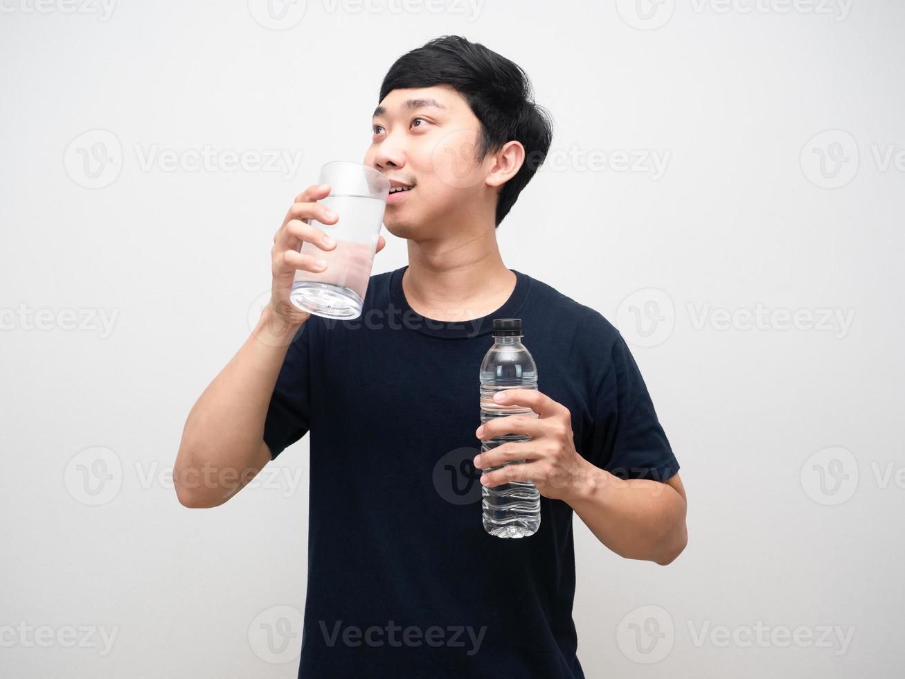 Young man black shirt drinking water and holding water bottle portrait photo