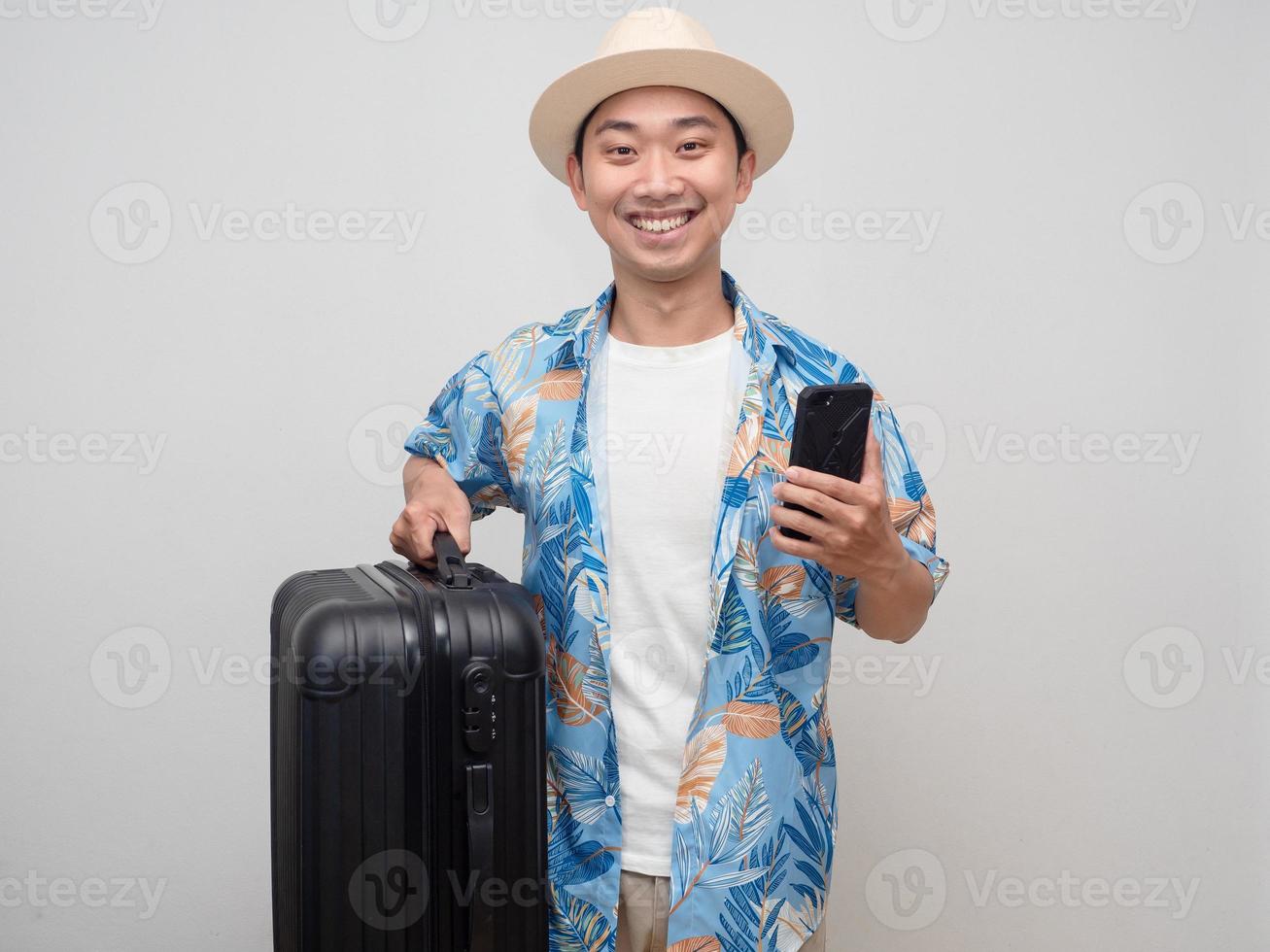 Portrait tourism man wear hat hold mobile phone with luggage happy smile isolated photo