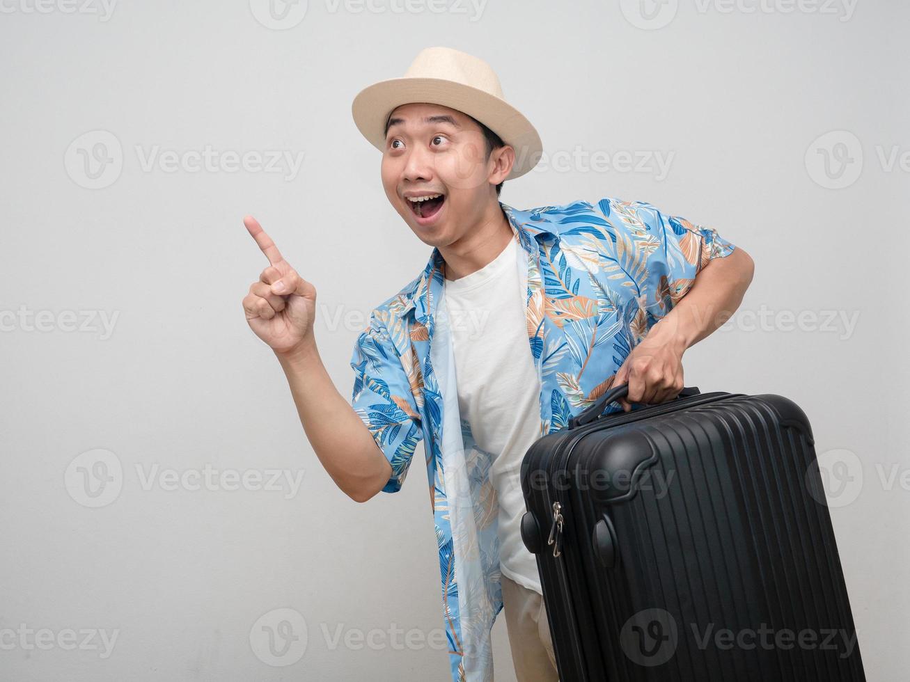 Positive man traveler wear hat with luggage gesture cheerful point finger photo