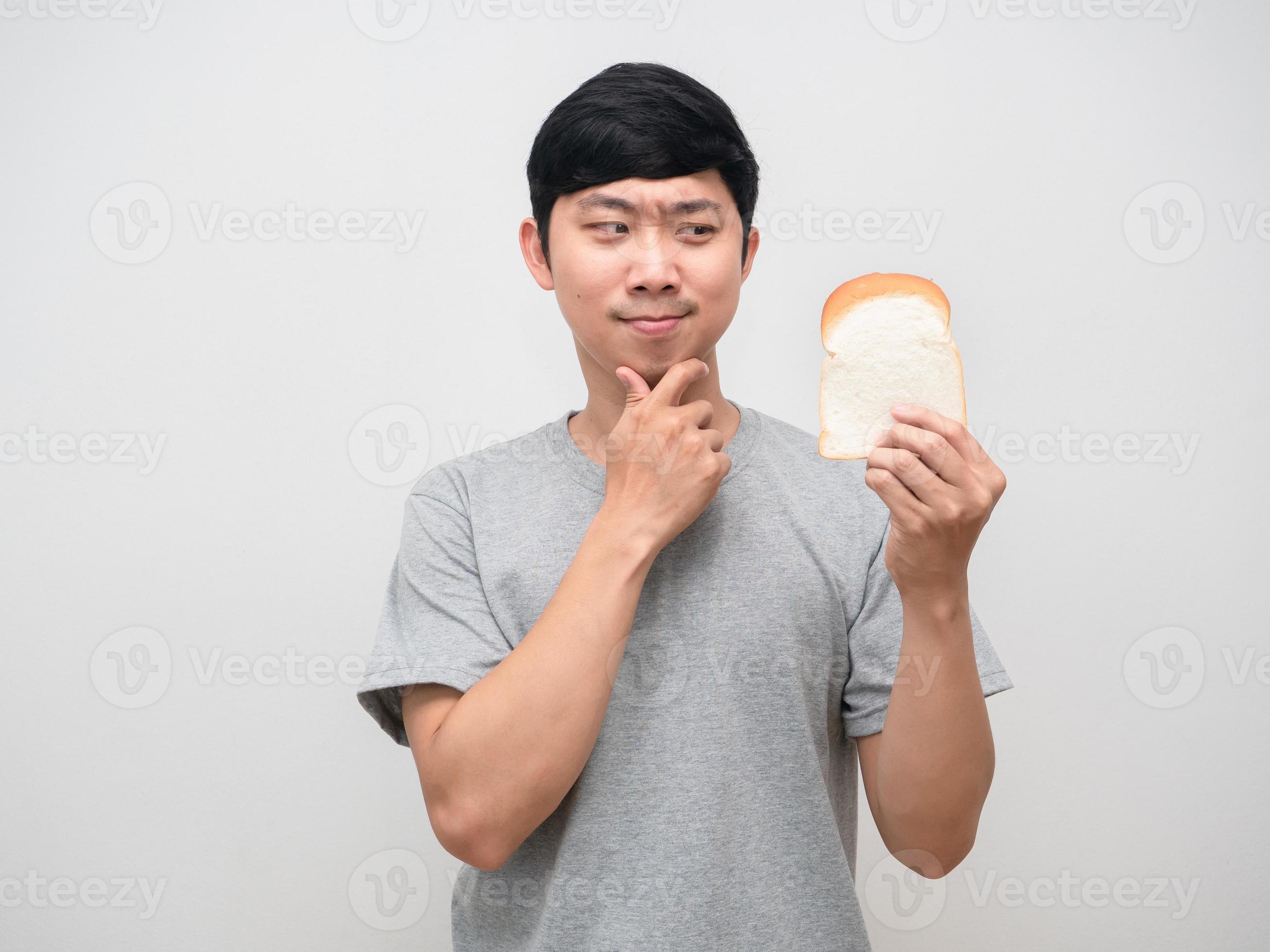 Young man hesitate to eat bread in hand 16790110 Stock Photo at Vecteezy
