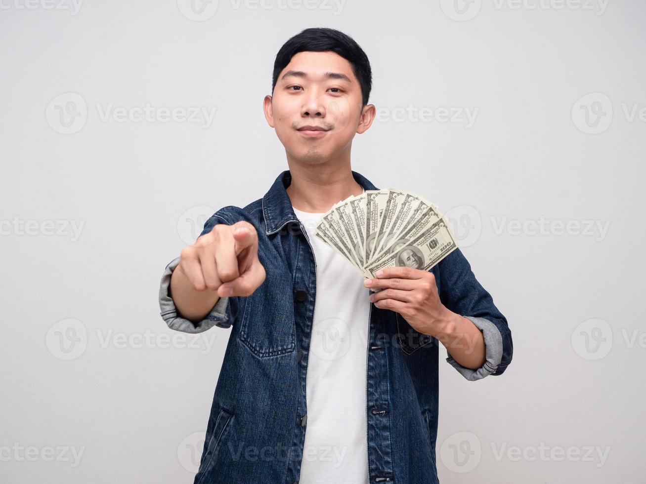 Handsome man jeans shirt hold money dollar and point finger at you photo