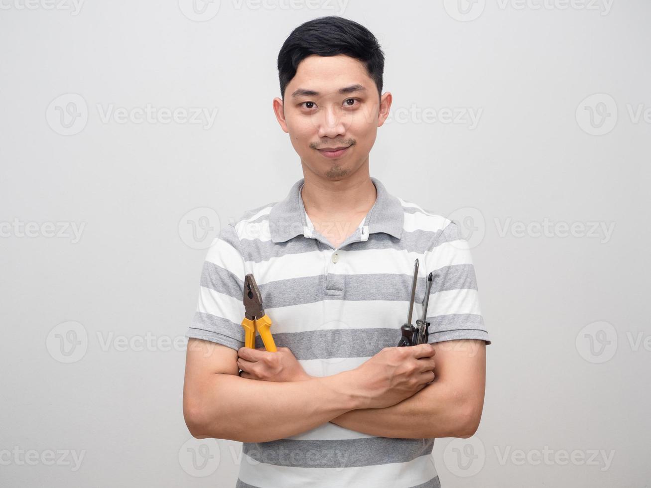 Young man striped shirt repair man concept confident hold pliers and screwdriver photo