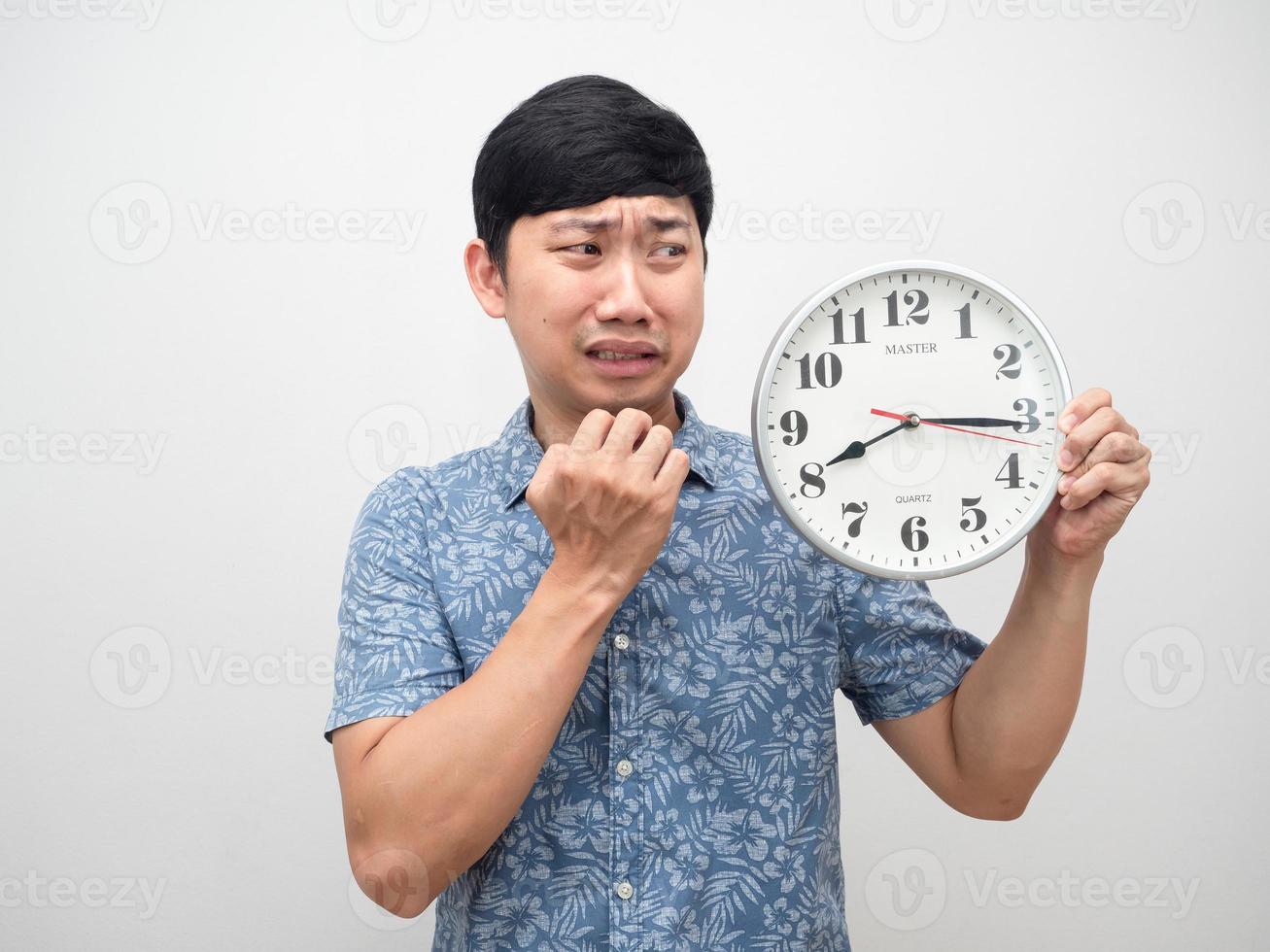 Man looking at clock feel shocked at face with working late isolated photo