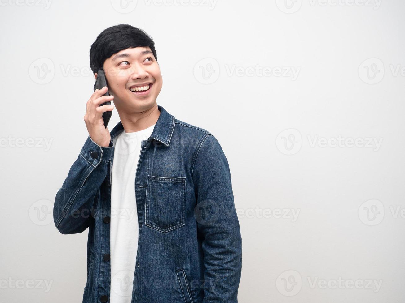 Young man jeans shirt talking with smartphone smiling turn face looking copy space photo