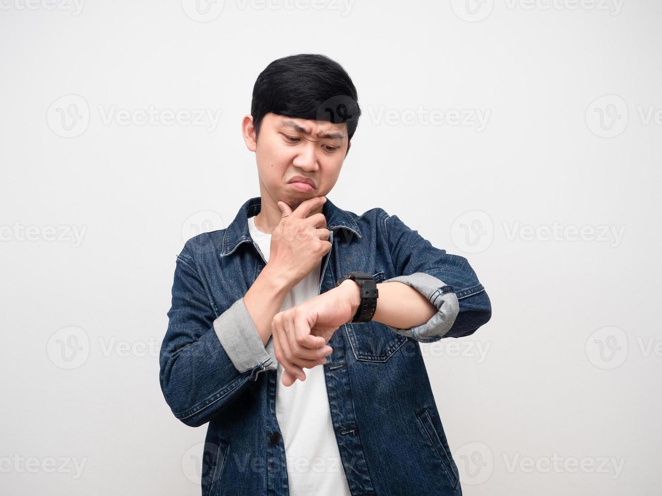 Asian man jeans shirt serious emotion  looking at his watch isolated photo