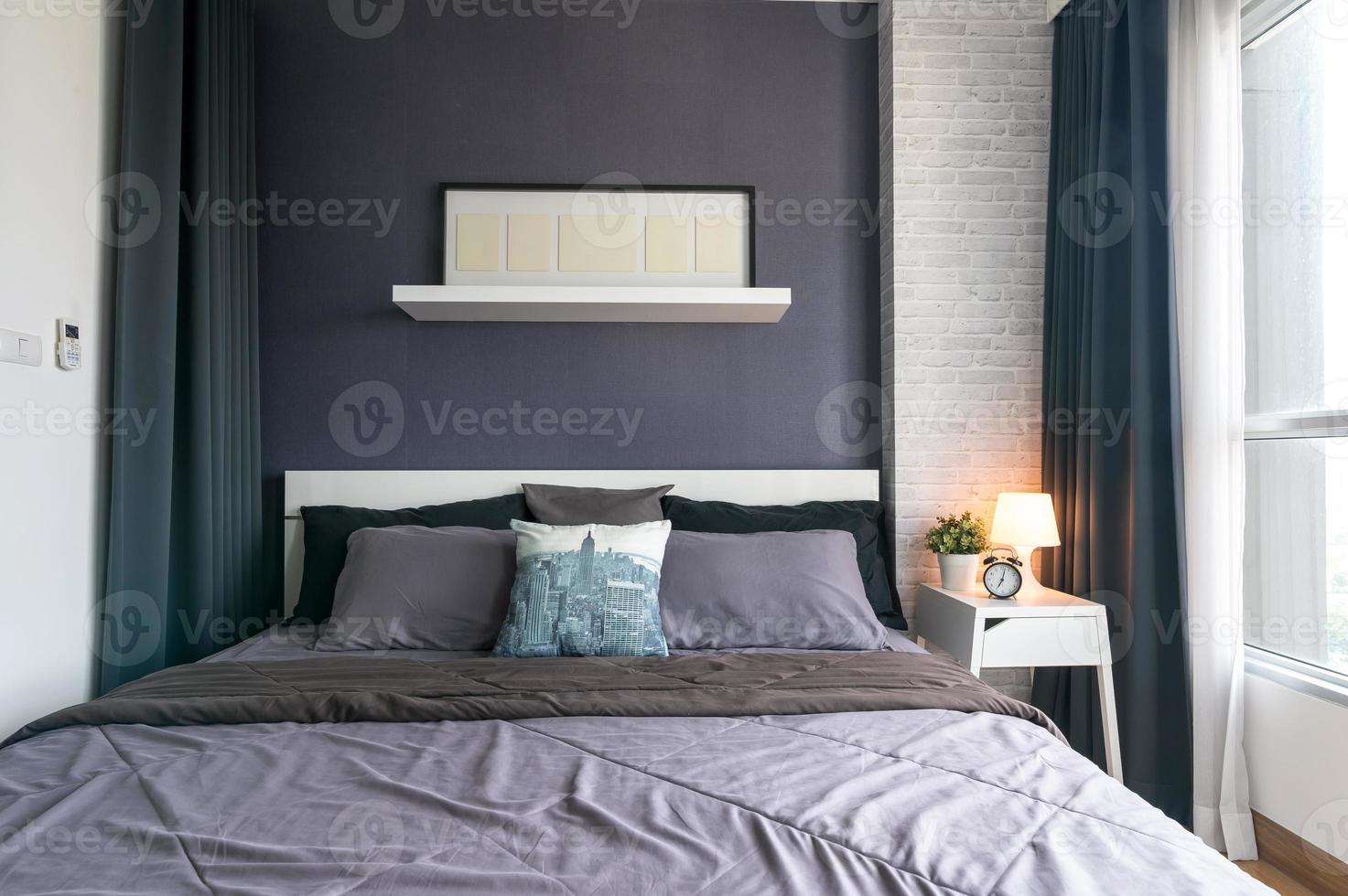 interior cálido y acogedor del espacio de la habitación con cama, marco de póster simulado. acogedora decoración del hogar. foto
