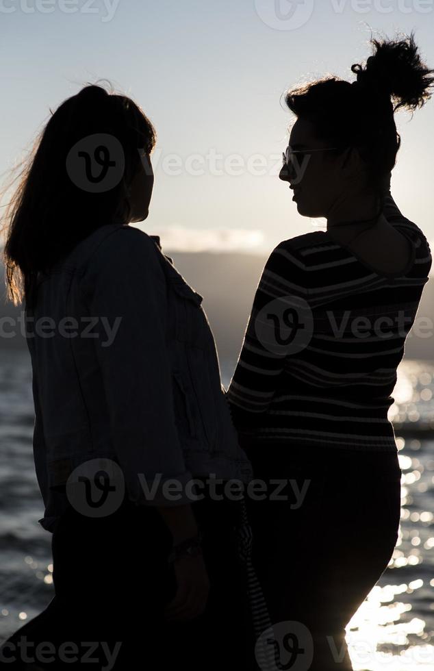 siluetas de novias al atardecer abrazándose. foto