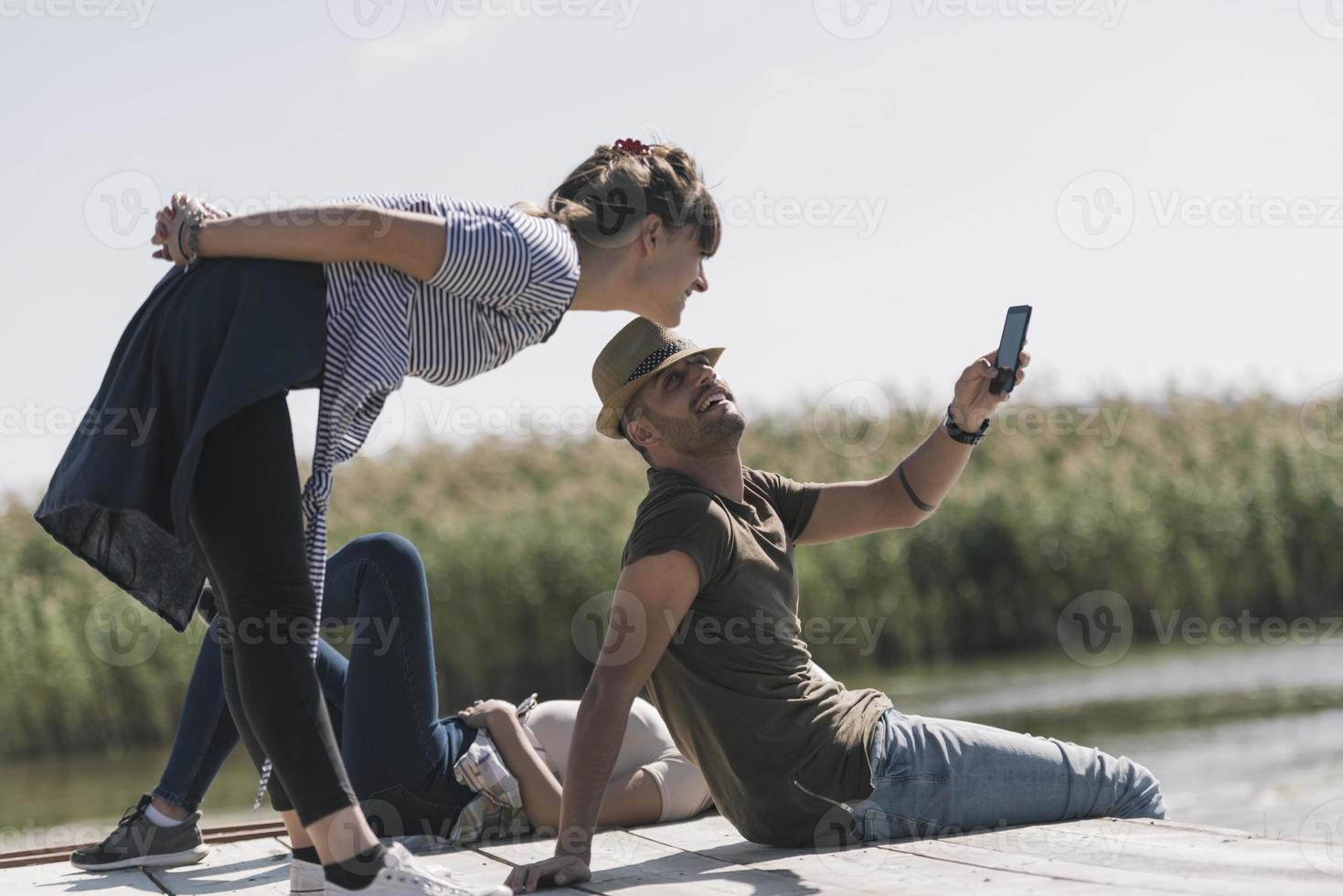 Picnic holiday concept. Beautiful couple having fun and relaxing by a lake. photo