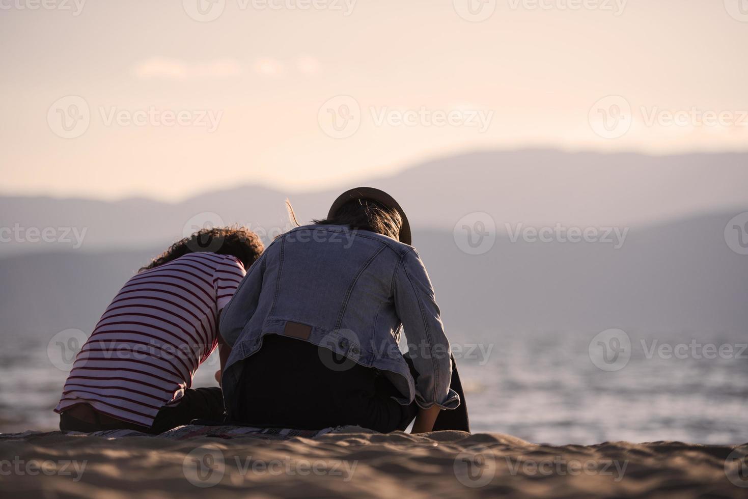 vista trasera de una feliz pareja romántica disfrutando de la hermosa puesta de sol en la playa. concepto de estilo de vida de jubilación de vacaciones de viaje foto