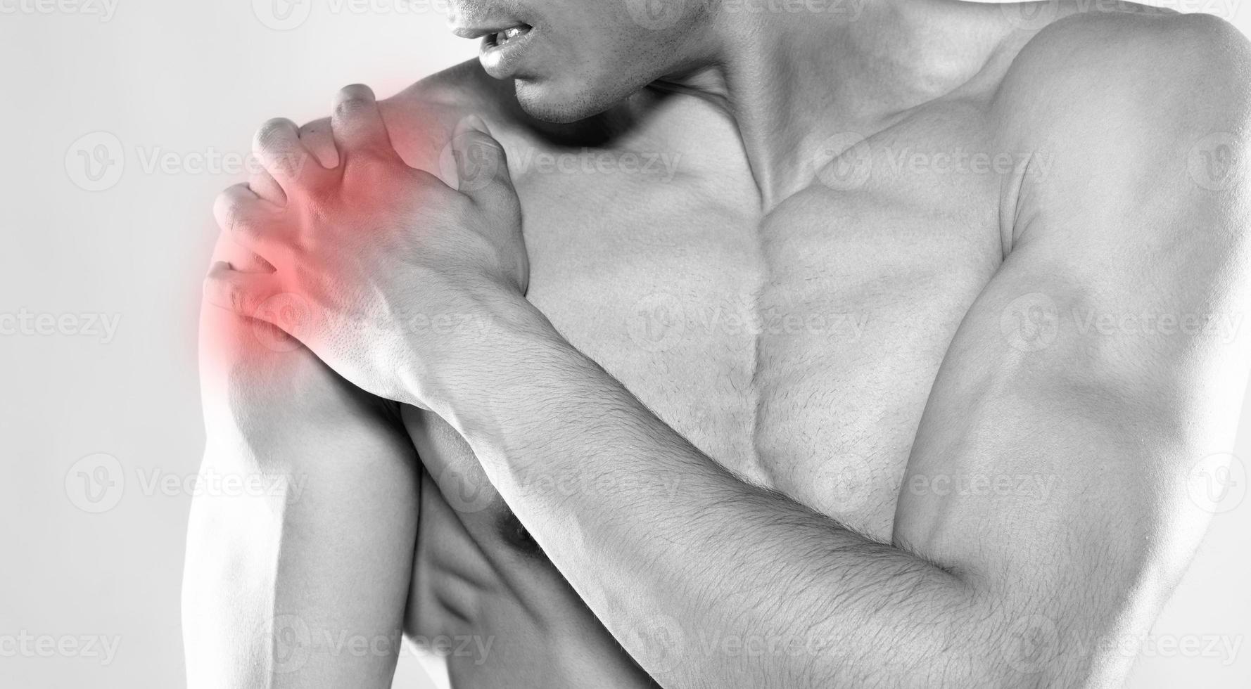 Young man has shoulder pain. hand touch shoulder. photo