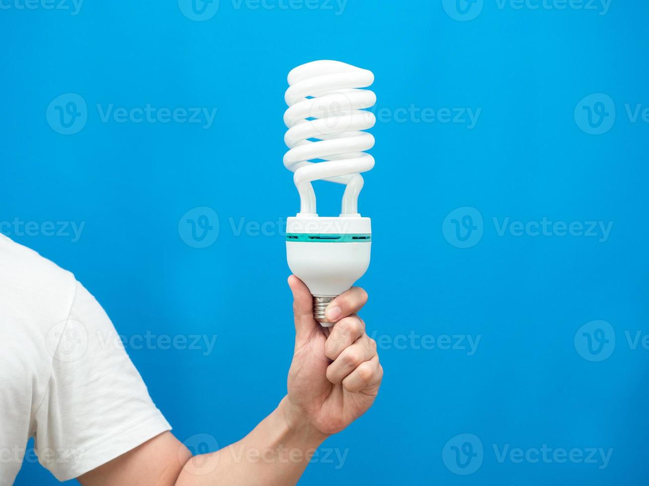 Hand holding light lamp energy save blue background isolated studio shot photo