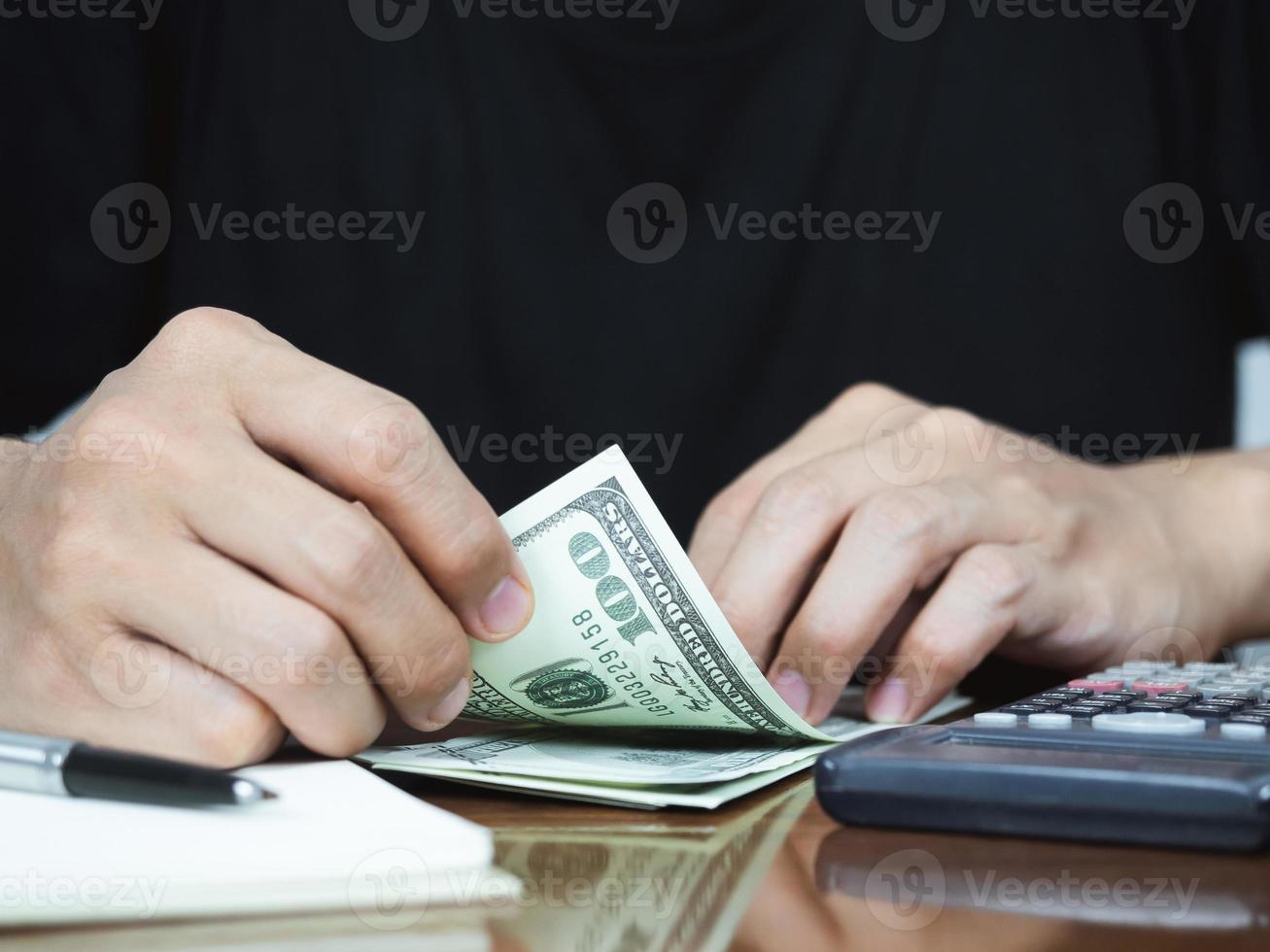 Closeup man hand counting a lot of money on table workplace photo