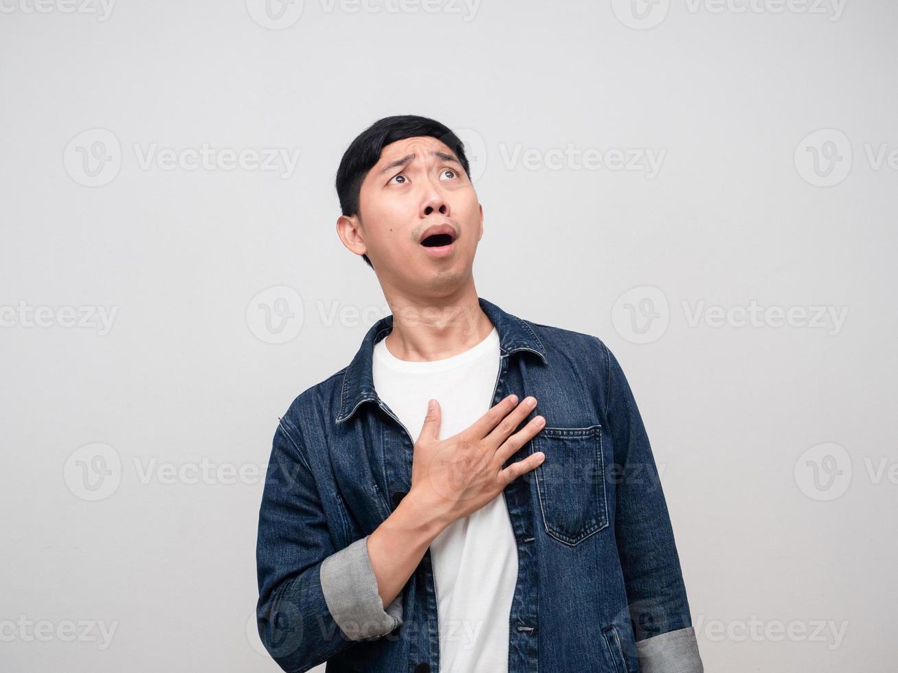 Young man jeans shirt touch his chest feels shocked looking above copy space photo