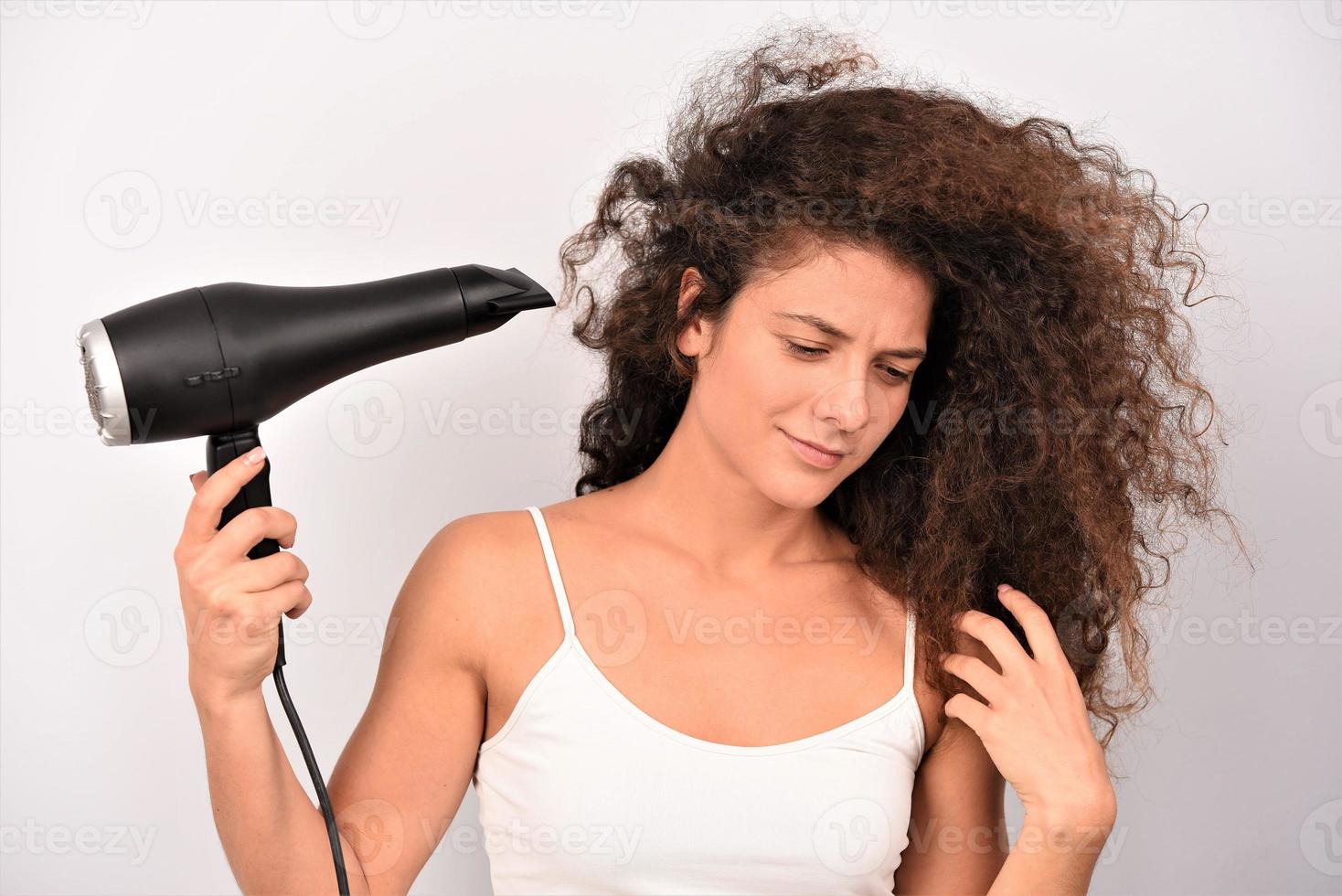 nice-looking attractive well-groomed cheerful cheery wavy-haired girl using electric dryer photo