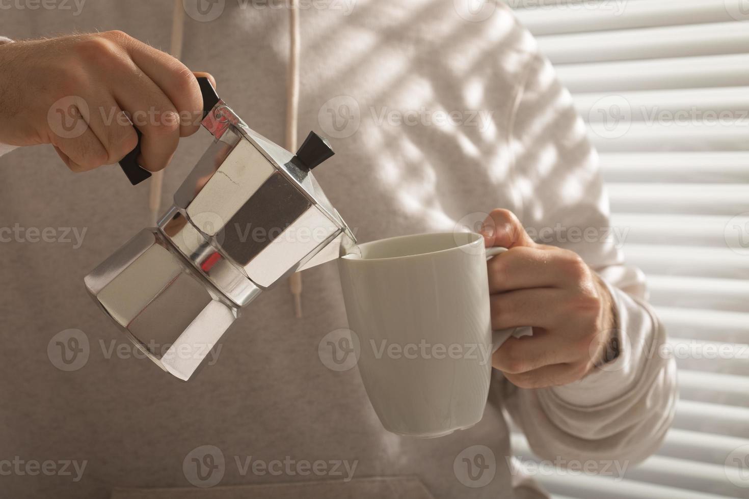 Close-up of male pouring coffee at office on summer day. Concept of invigorating morning and positive mood photo