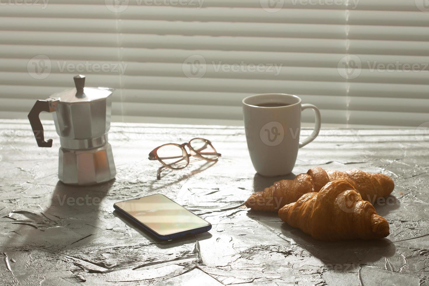 Breakfast with croissant and coffee and moka pot. Morning meal and breakfast concept. photo