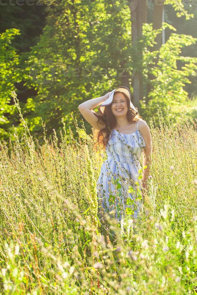 Woman walking in a field in summer sunny day. photo