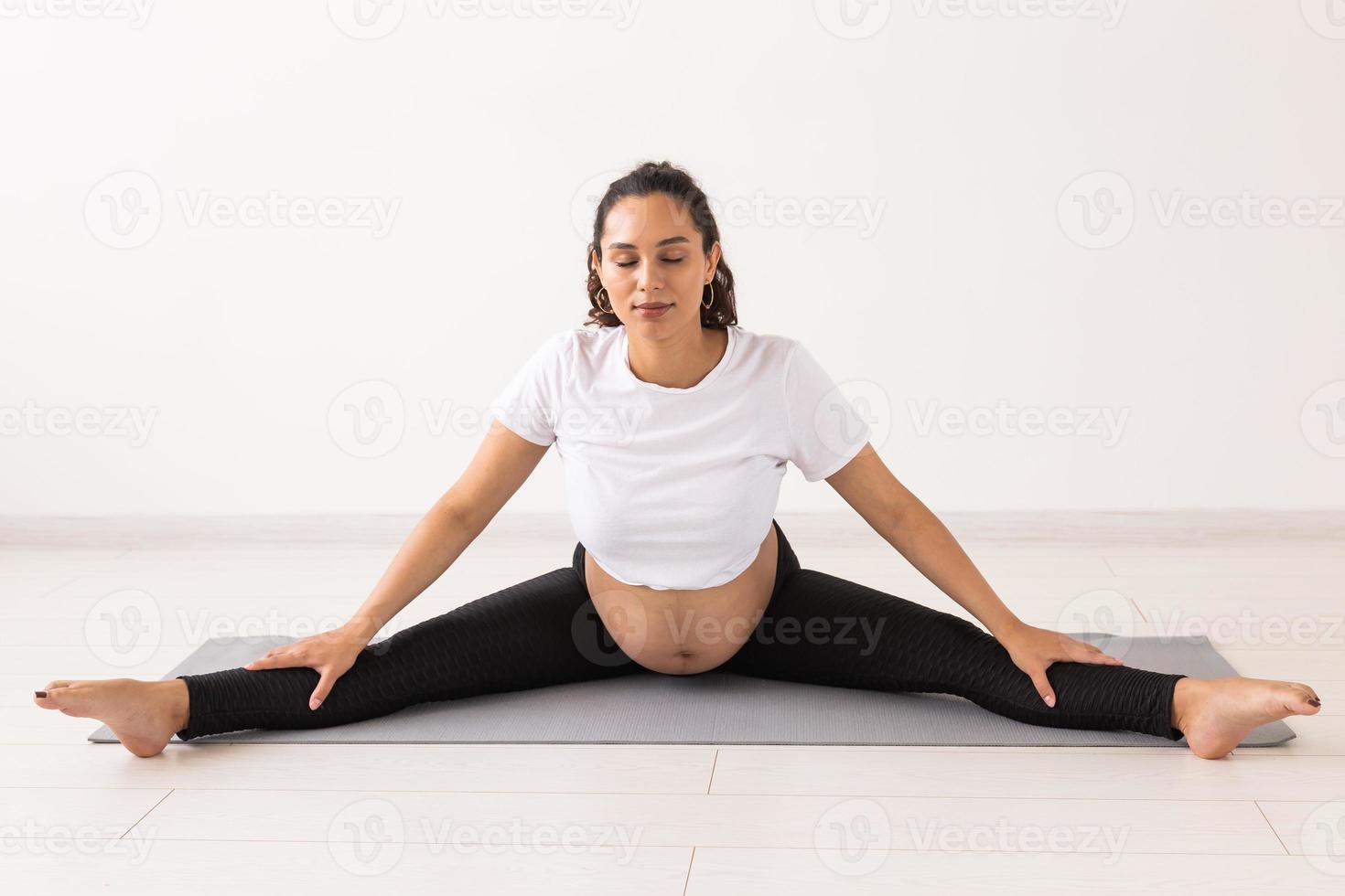 mujer embarazada sana haciendo gimnasia en casa. embarazo, estilo de vida saludable y licencia de maternidad foto