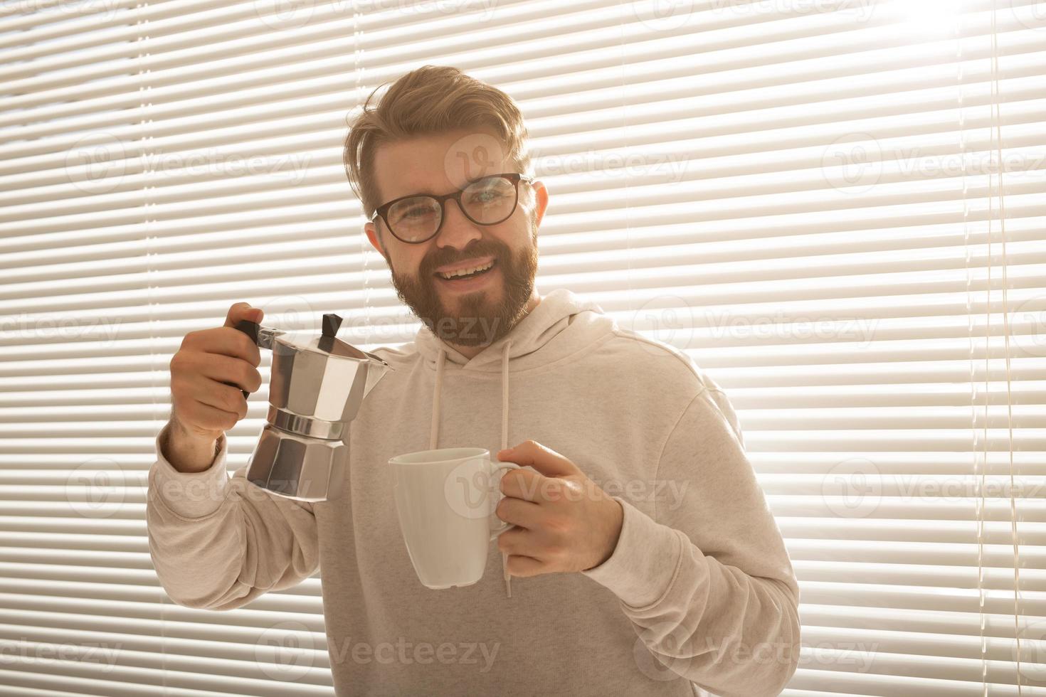Young man pouring coffee from moka pot at morning. Breakfast and break concept. photo