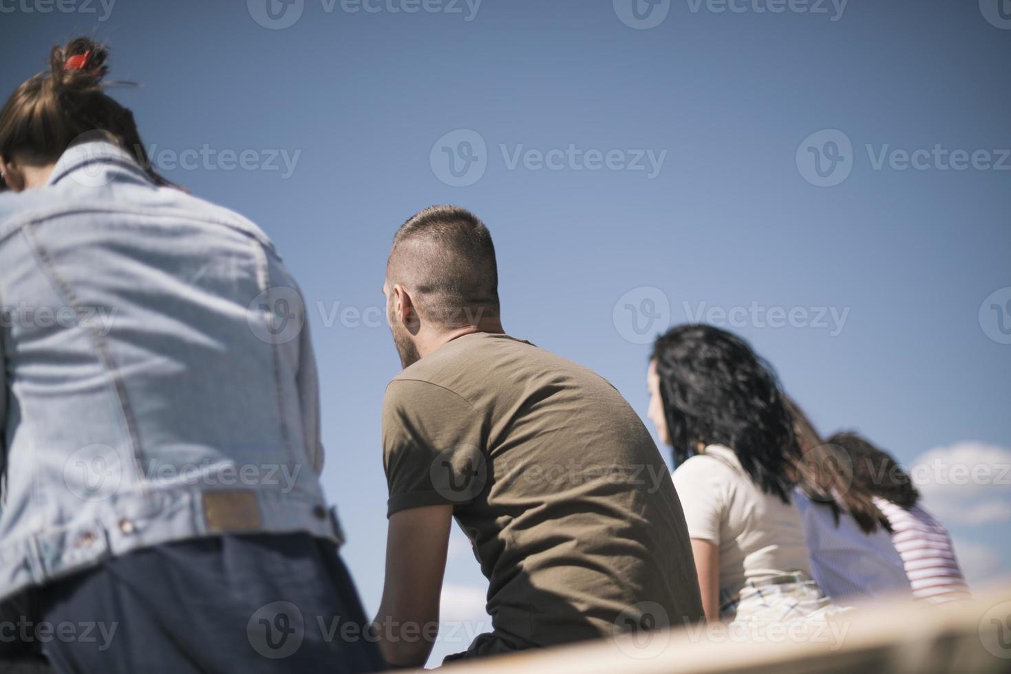 Group of friends having fun  and relaxing by a lake. photo