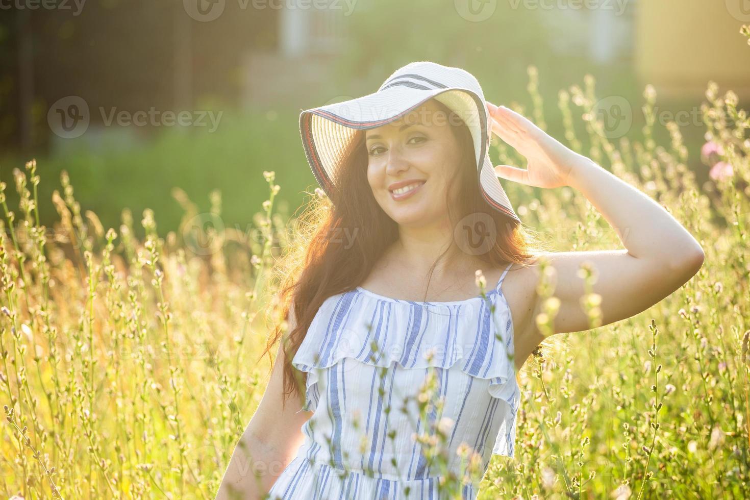 Young woman walking among wildflowers on sunny summer day. Concept of the joy of communicating with summer nature photo