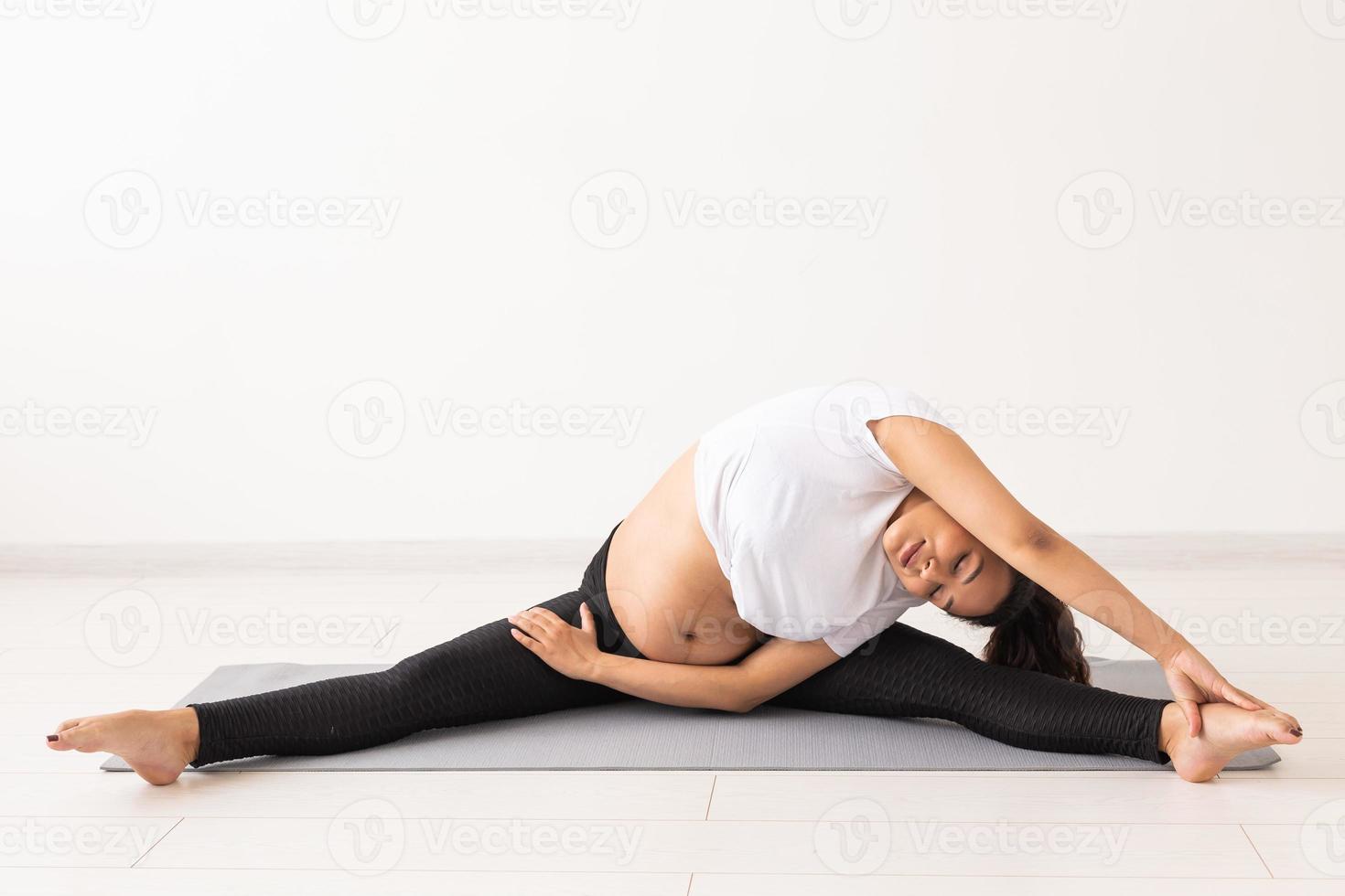 Healthy pregnant woman doing gymnastic at home. Pregnancy, healthy lifestyle and maternity leave photo