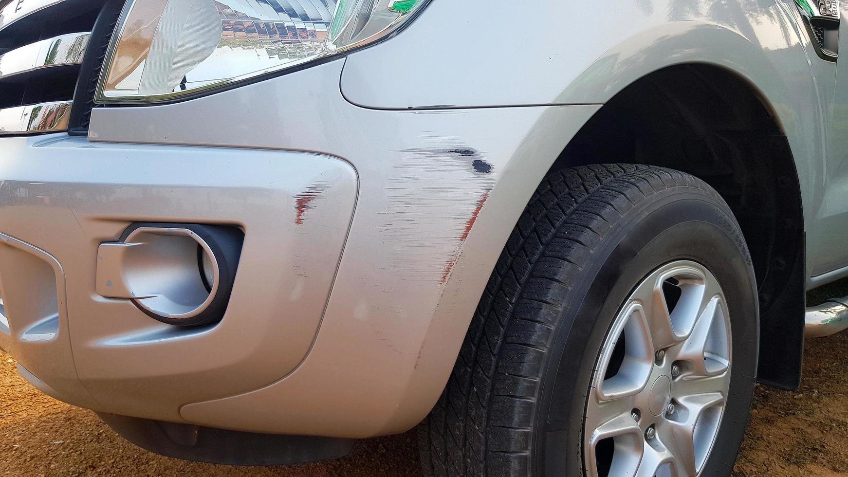 arañazos en un camión gris, gris o bronce después de un accidente y un objeto de choque. dañado en el parachoques delantero. concepto de automóvil o vehículo dañado y lesionado. foto