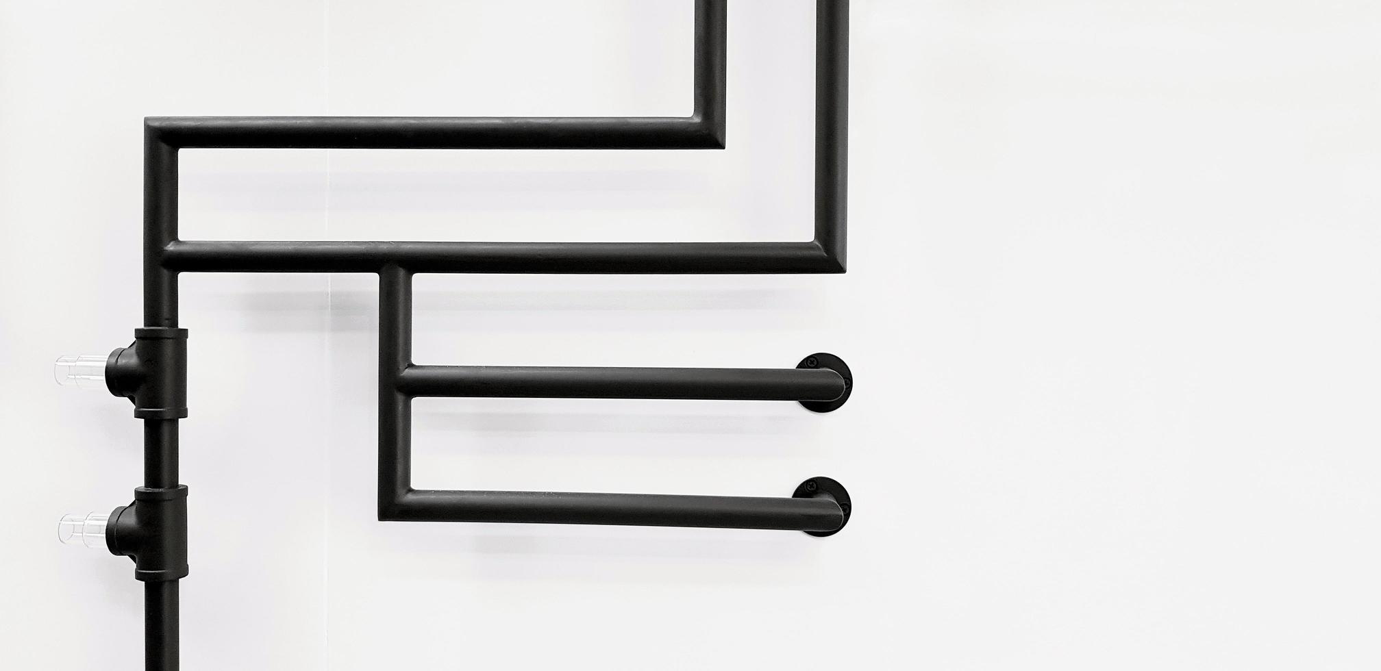 hermoso diseño de tubería de agua negra aislada en fondo blanco con espacio de copia. línea de golpeteo de tubería oscura en la pared. concepto interior o exterior moderno foto