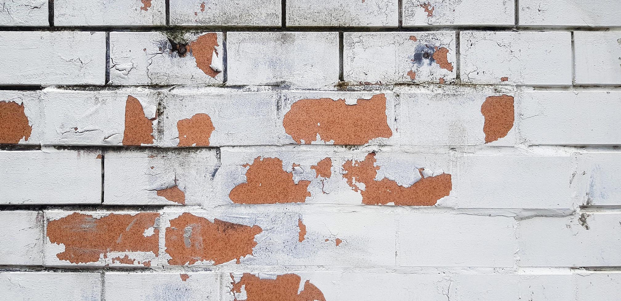 The white painted brick wall cracked for background. Pattern line of wallpaper. Exterior damaged and injured. Dirty or mess structure of home or house. photo