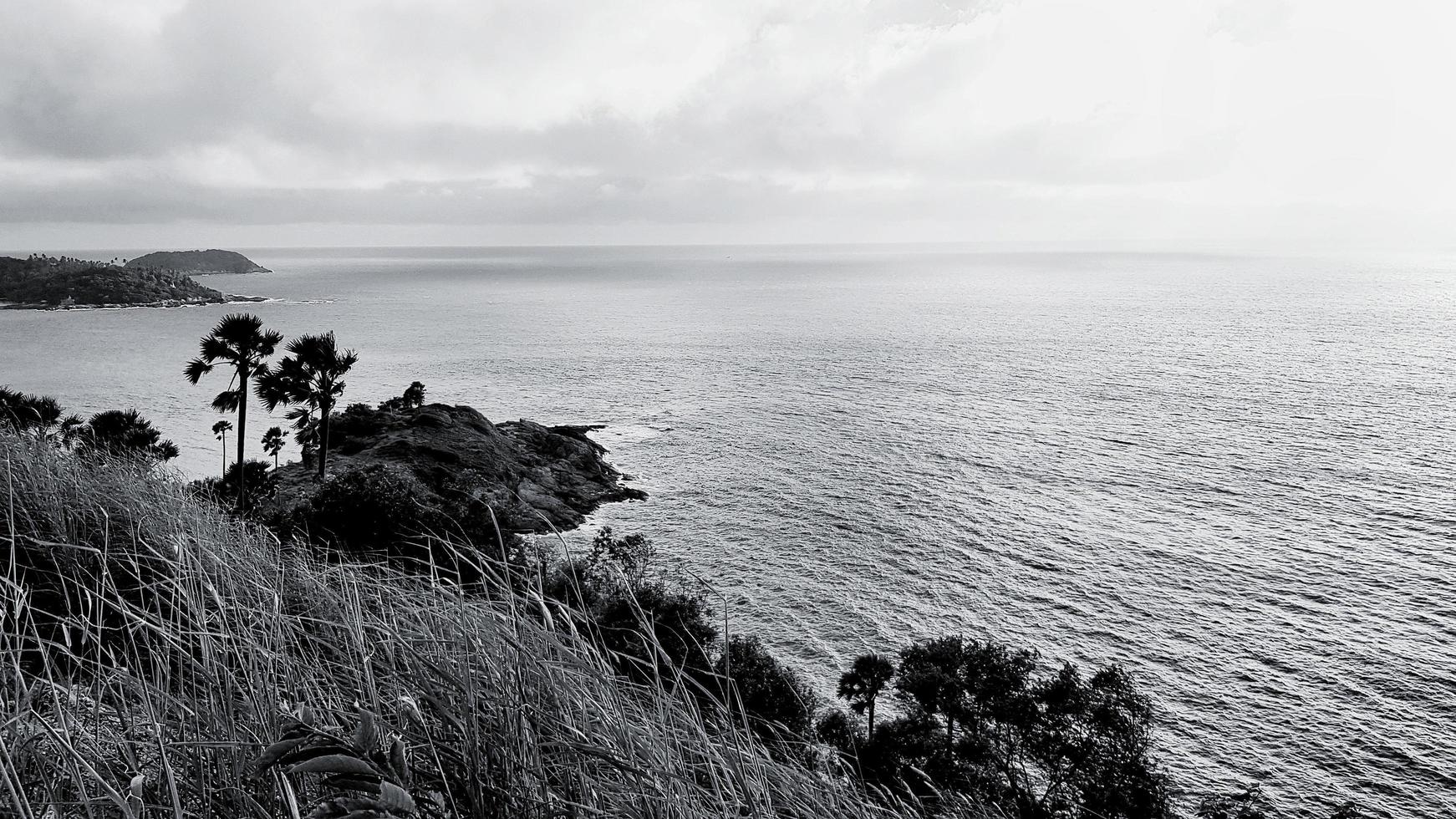 Beautiful Promthep cape with grass field and palm or coconut trees with sky and clouds background in black and white tone. Beauty in nature, Landmarks south of Thailand for tourists travel to visit. photo