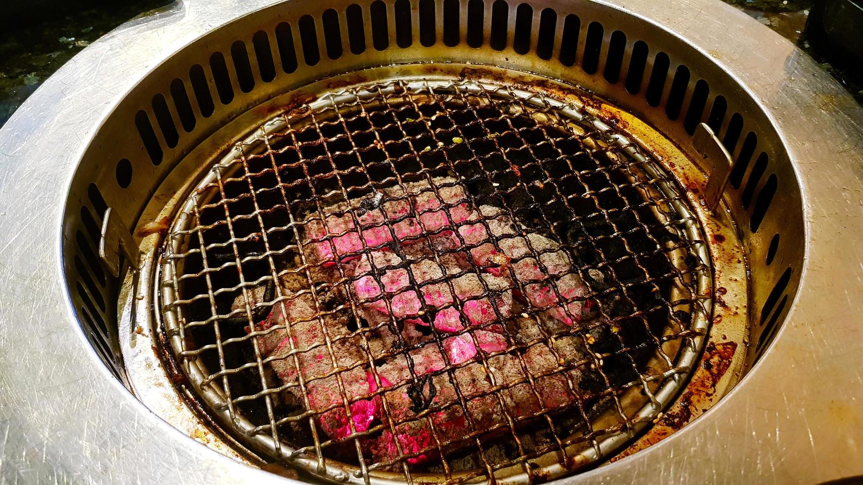 Estufa de parrilla de carbón con red de acero inoxidable para asar a la parrilla en restaurantes coreanos. equipo para cocinar o hacer comida. foto