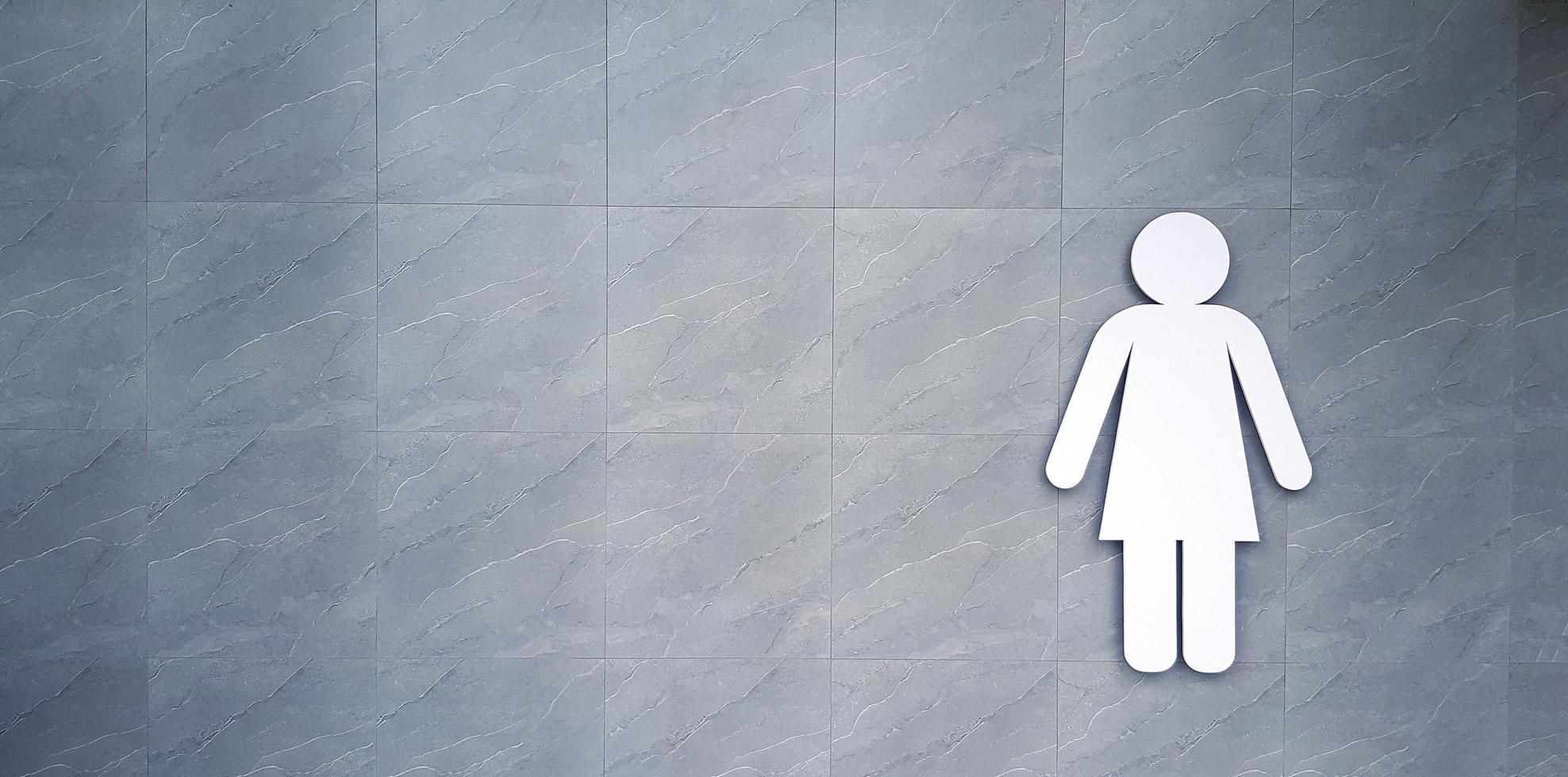 White toilet sign on gray marble background with copy space at public place. The logo for tell people this washroom or restroom for women use only on grey cement wall. Exterior design photo