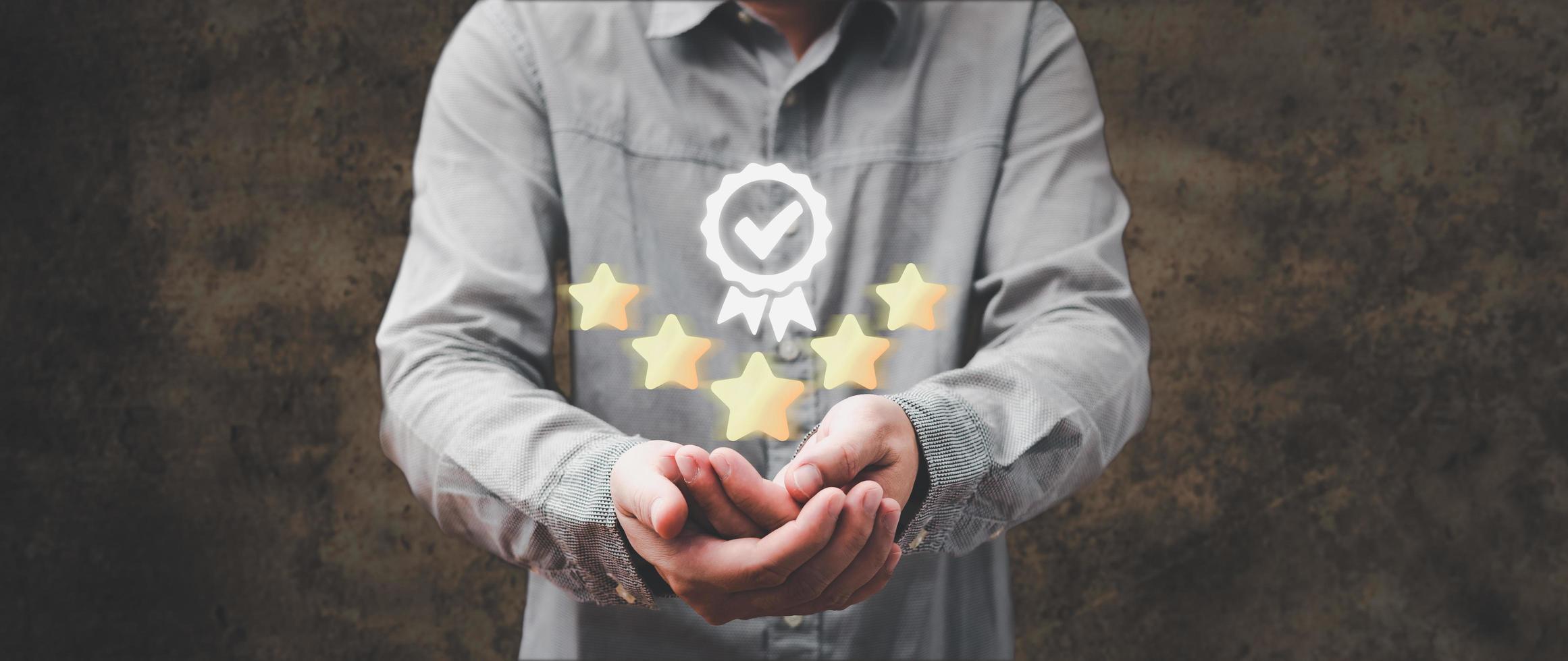 la mano de la persona sosteniendo y mostrando el signo del mejor servicio de garantía de calidad cinco estrellas doradas, certificación iso, estándares, garantía y concepto de estandarización foto