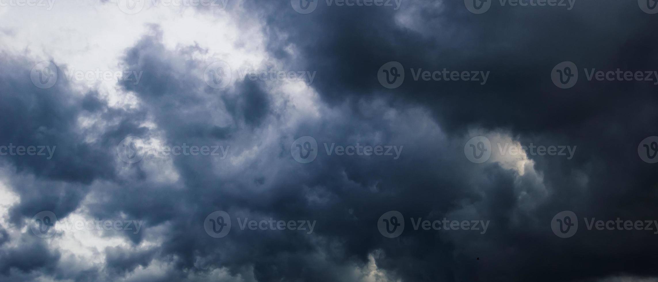 The dark sky with heavy clouds converging and a violent storm before the rain.Bad or moody weather sky and environment. carbon dioxide emissions, greenhouse effect, global warming, climate change. photo