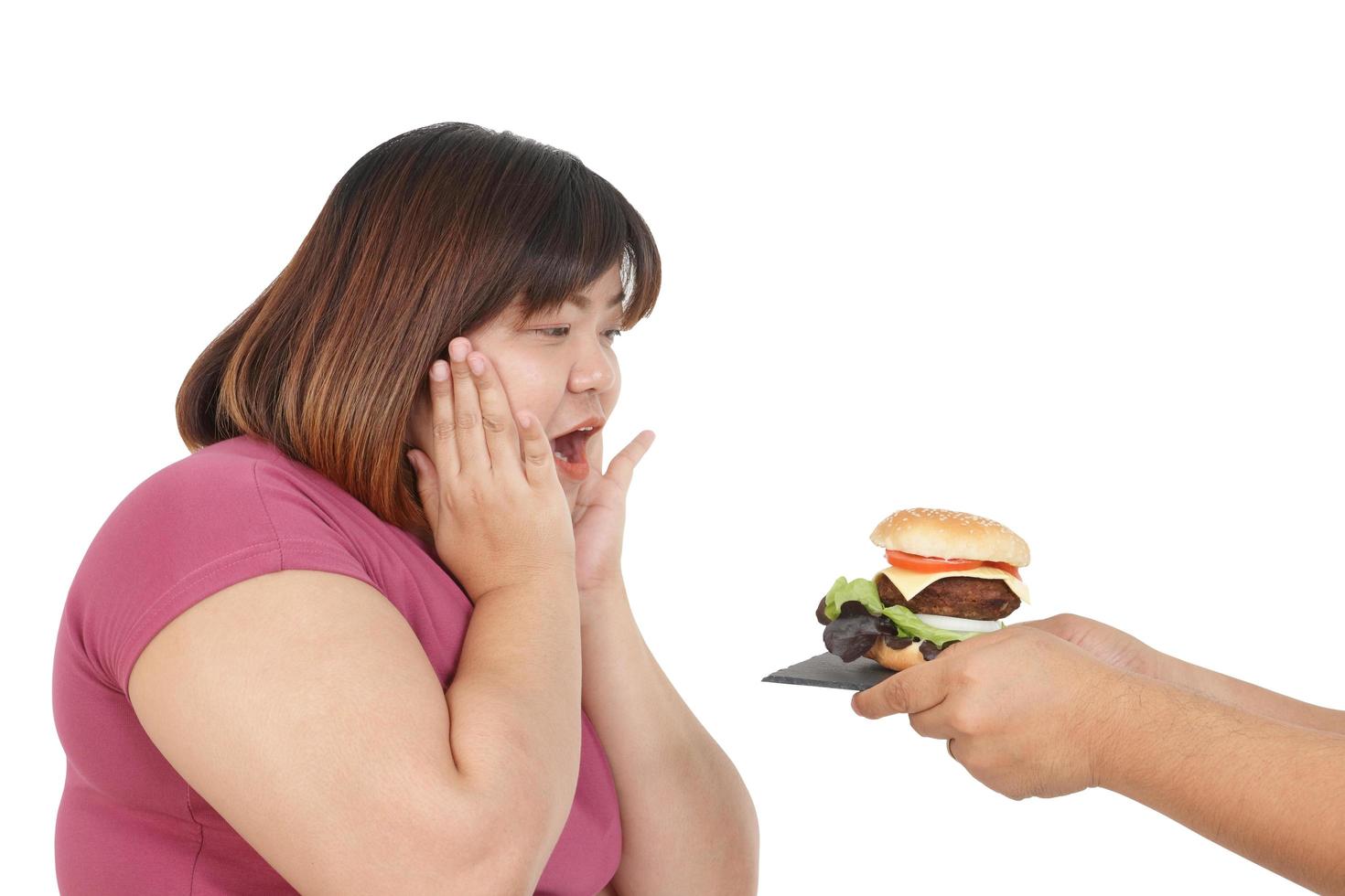 mujer asiática gorda con ropa de ejercicio para perder peso, postura feliz, alguien le dio una hamburguesa. concepto de problemas de salud de las personas obesas. Fondo blanco foto