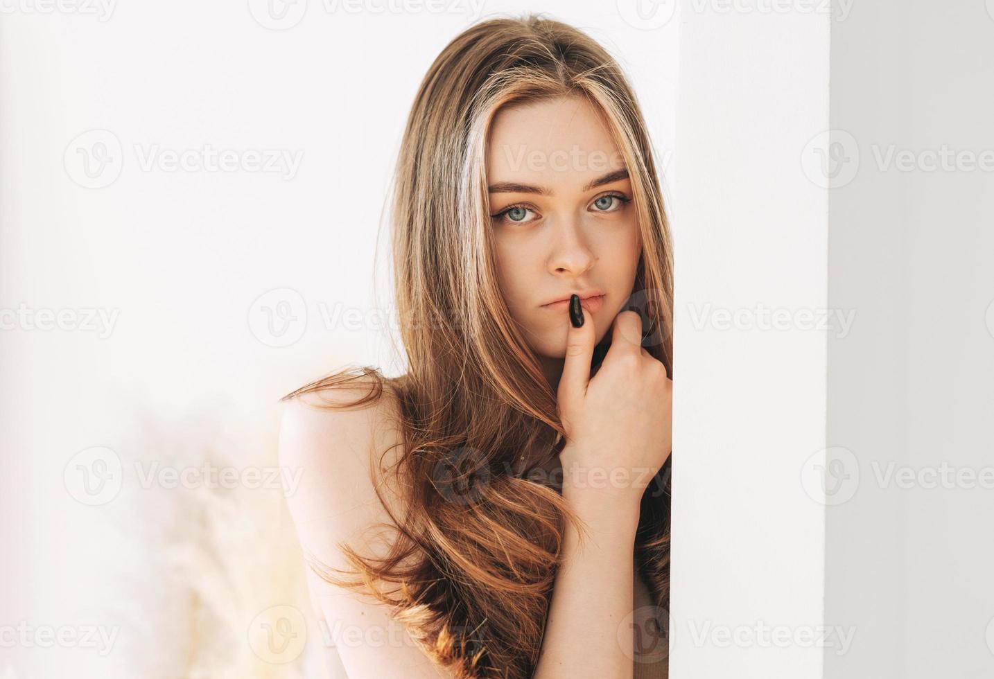 hermosa joven modelo de moda de belleza con el pelo largo mirando a la cámara en el fondo blanco foto