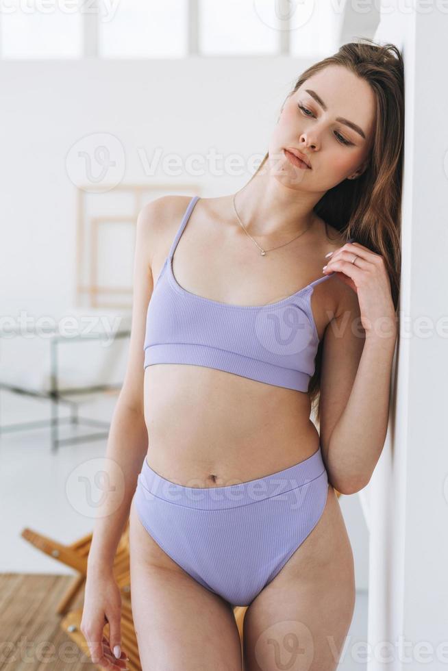 https://static.vecteezy.com/system/resources/previews/016/799/299/non_2x/beautiful-young-woman-beauty-fashion-model-with-long-hair-in-light-purple-sport-seamless-ribbed-underwear-looking-at-camera-in-the-bright-studio-photo.jpg