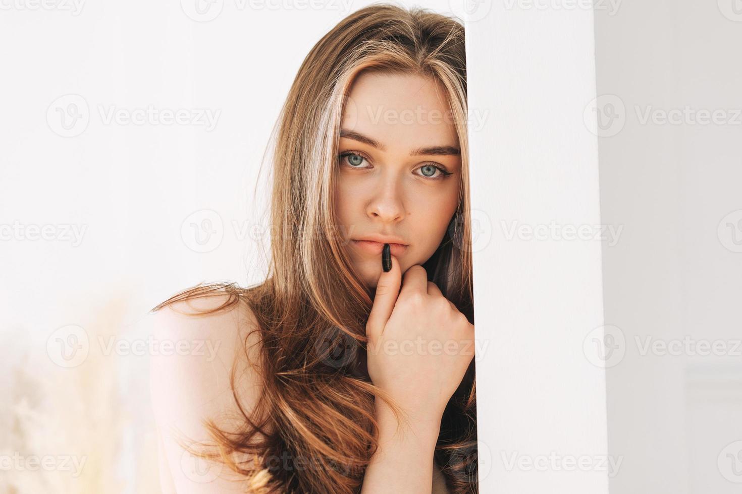 hermosa joven modelo de moda de belleza con el pelo largo mirando a la cámara en el fondo blanco foto
