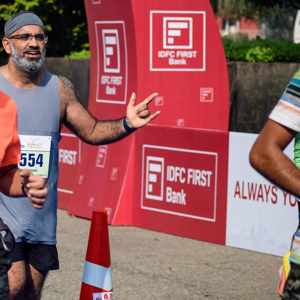 nueva delhi, india - 16 de octubre de 2022 - carrera de media maratón de vedanta delhi después de covid en la que los participantes del maratón están a punto de cruzar la línea de meta, media maratón de delhi 2022 foto