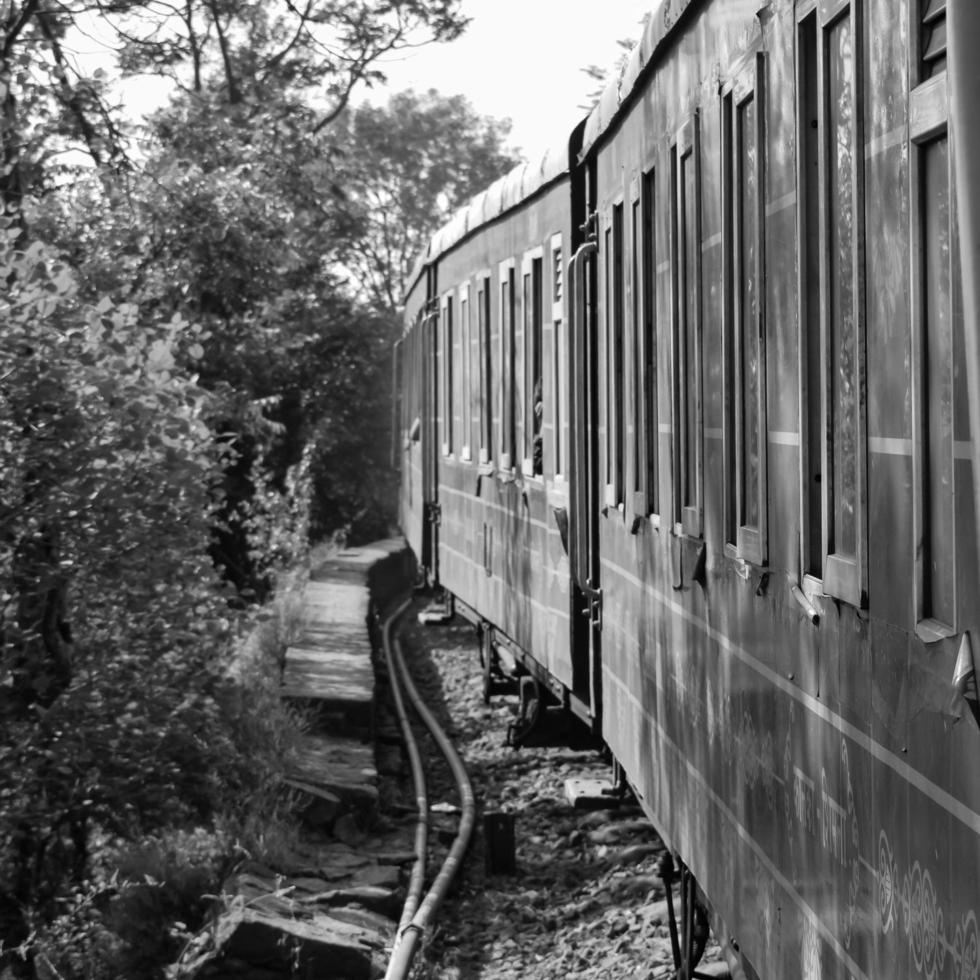 Shimla, Himachal Pradesh, India - May 14, 2022 - Toy train Kalka-Shimla route, moving on railway to the hill, Toy train from Kalka to Shimla in India among green natural forest photo