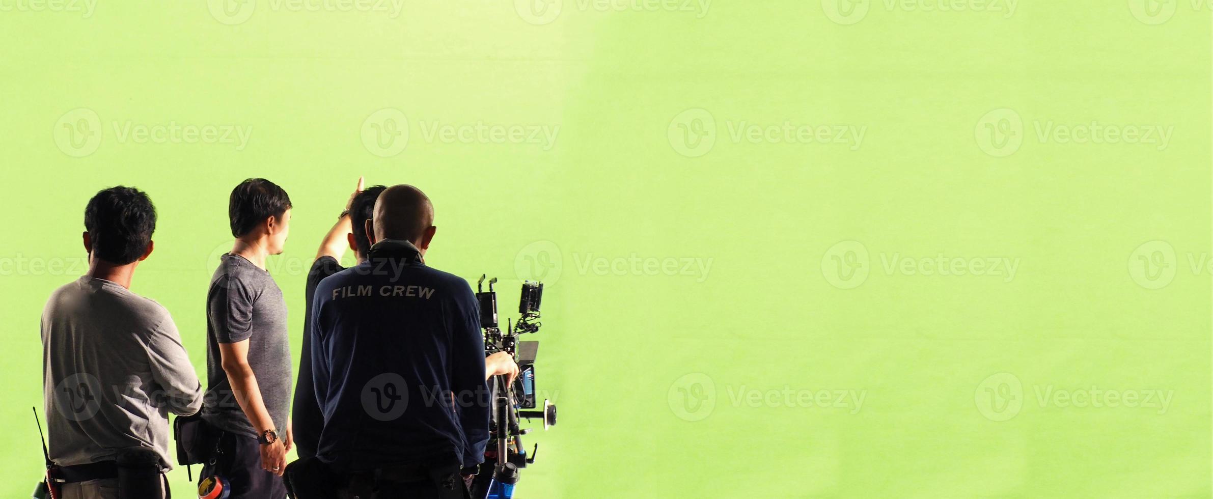 Camera and green screen studio in panorama view and man working or shooting or recording or filming. photo