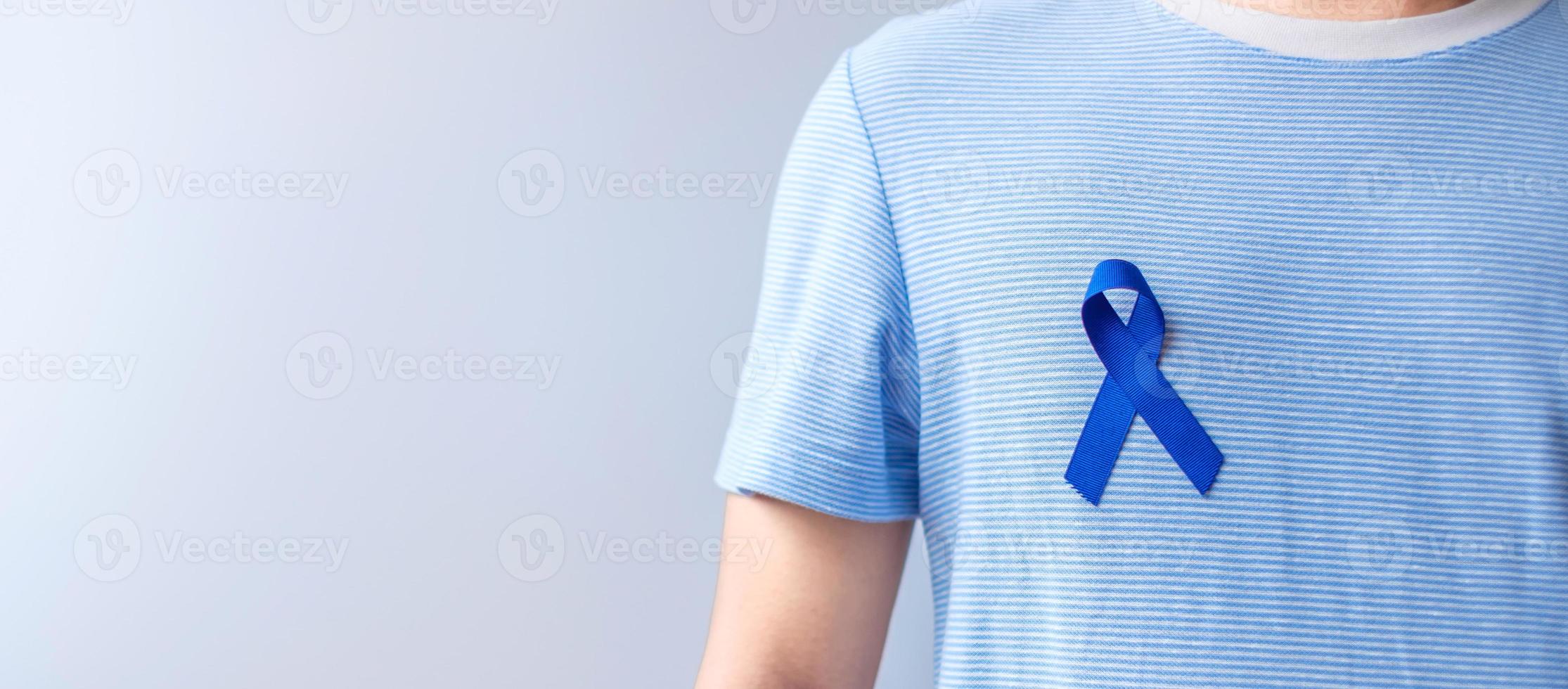 marzo mes de concientización sobre el cáncer colorrectal, mujer sosteniendo una cinta azul oscuro para apoyar a las personas que viven y están enfermas. concepto de salud, esperanza y día mundial contra el cáncer foto