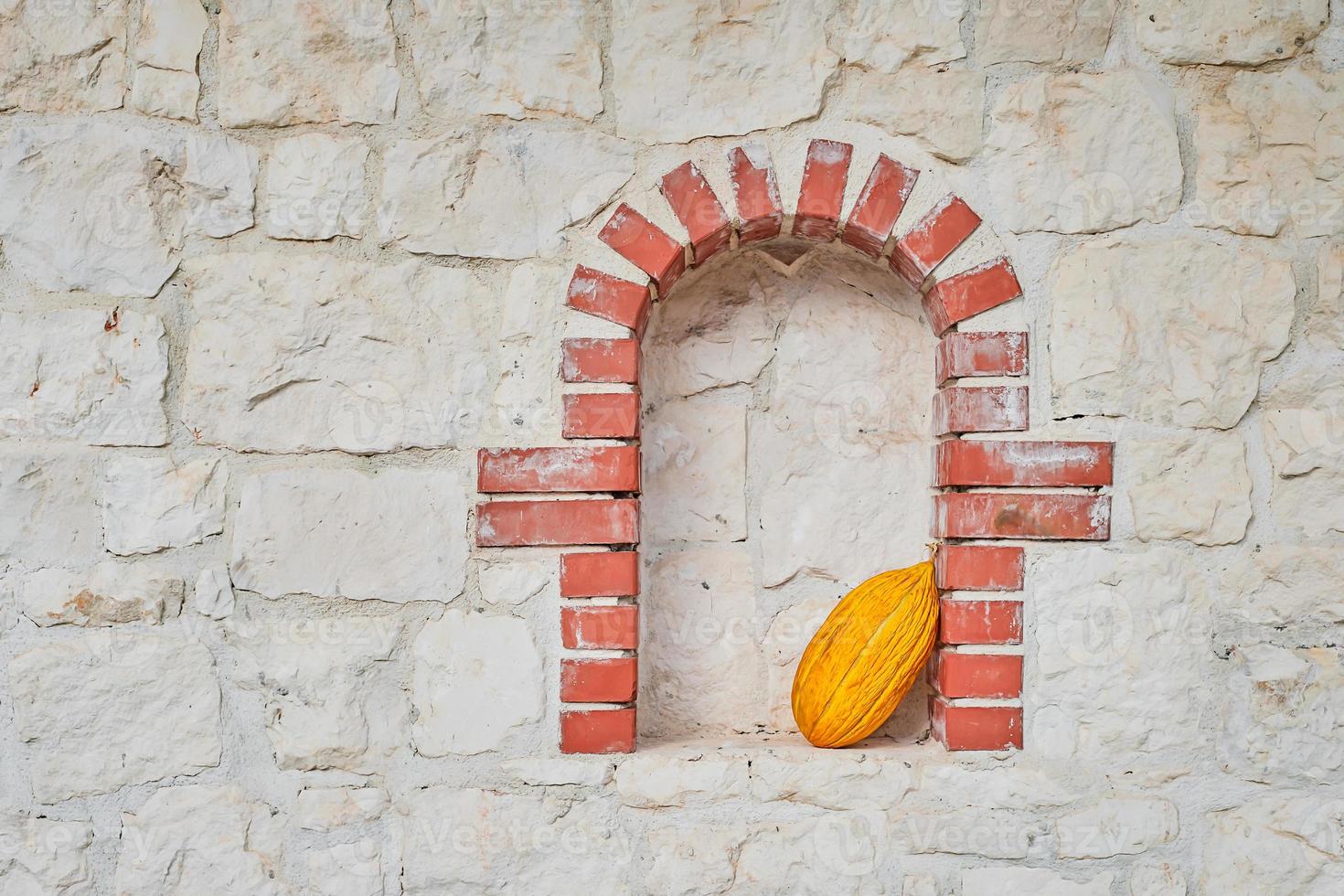 Yellow Turkish melon in a niche on a stone wall, photo with copy space, fruits from a farmers market. Idea for background or product article