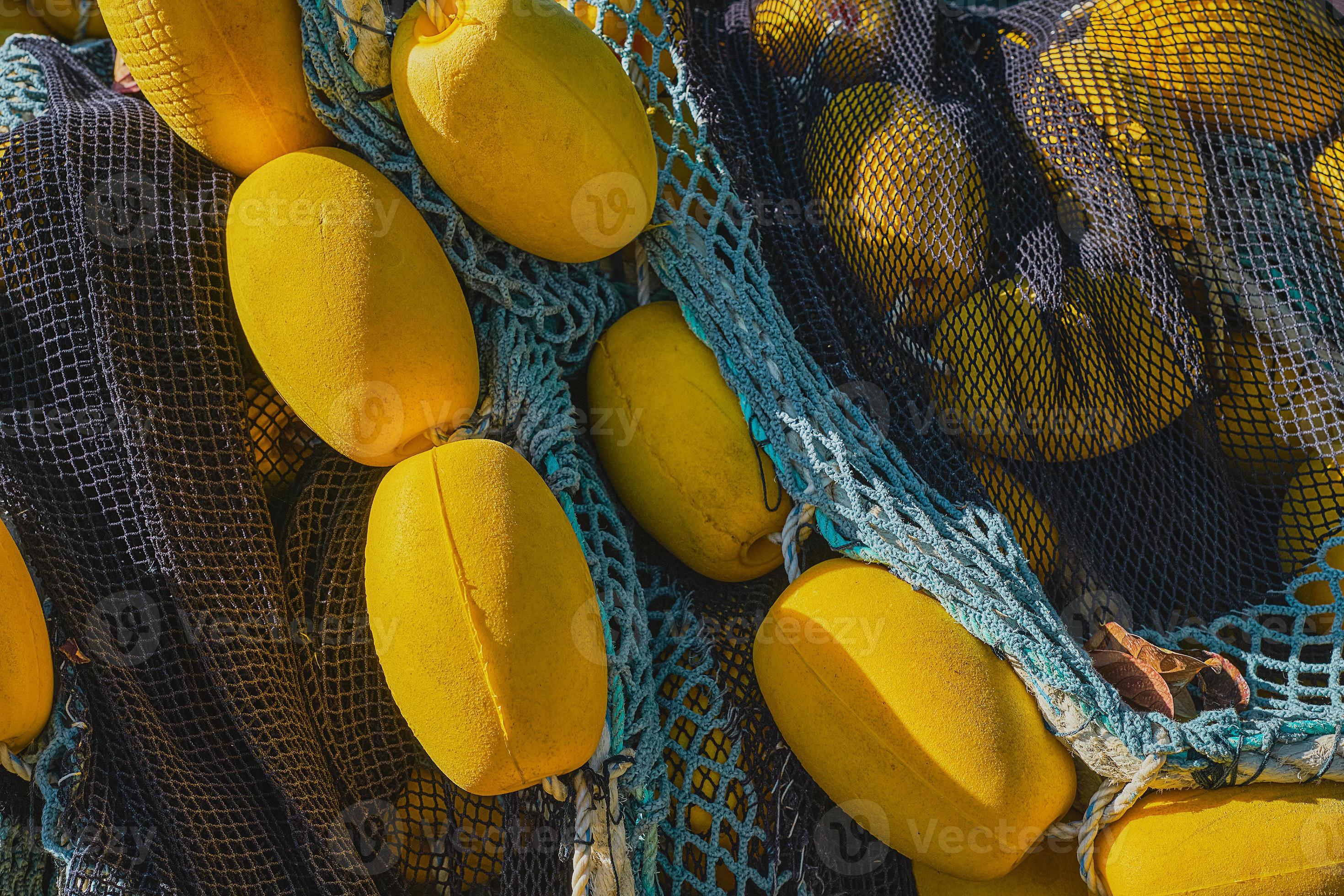 Fishing net with yellow floats dries on the pier, close-up