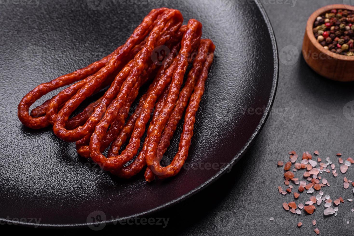 Delicious thin smoked meat sausages with spices and herbs photo