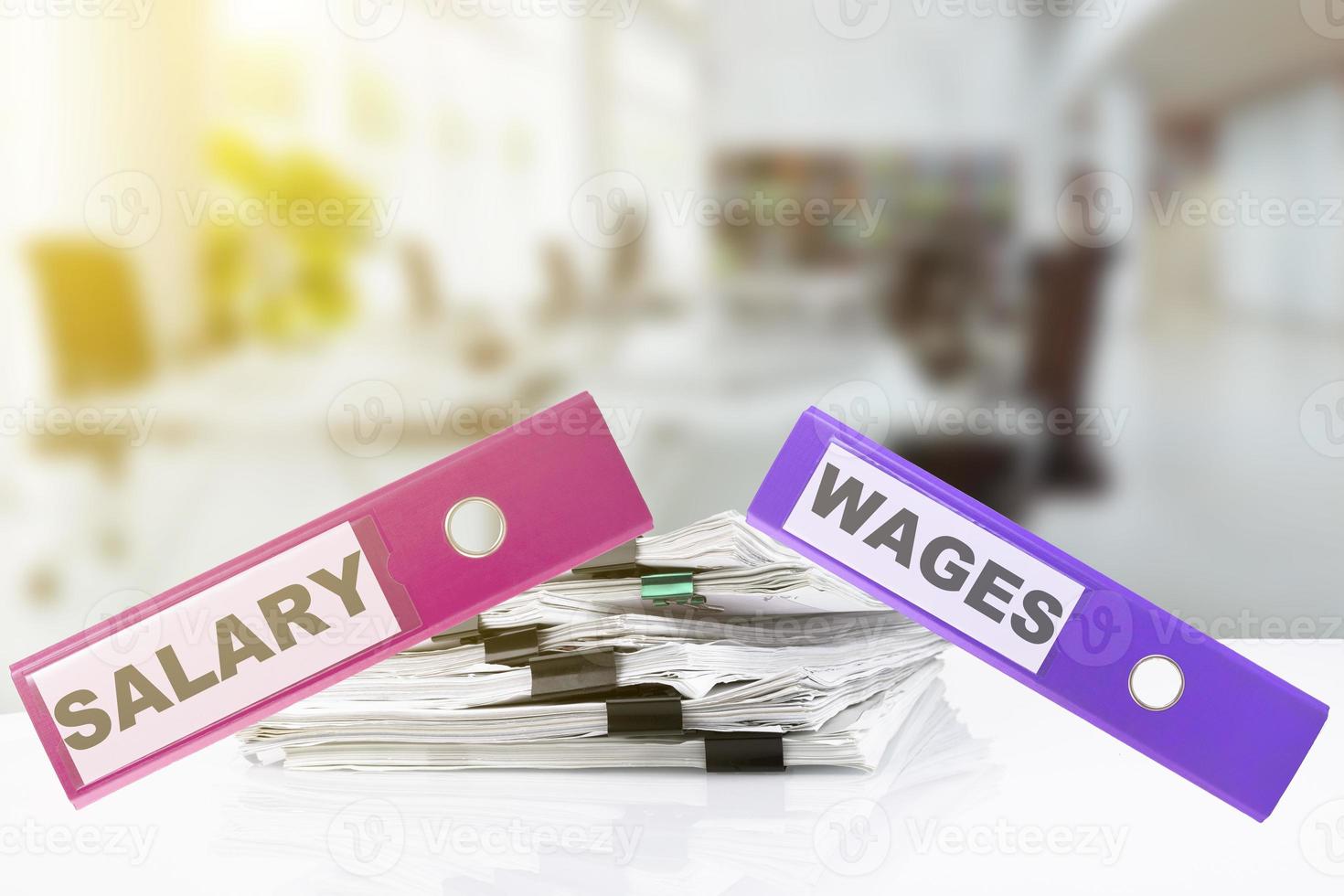 Wages, Salary, words written on office folders lying on a desk in a business office. Blurred office background. photo